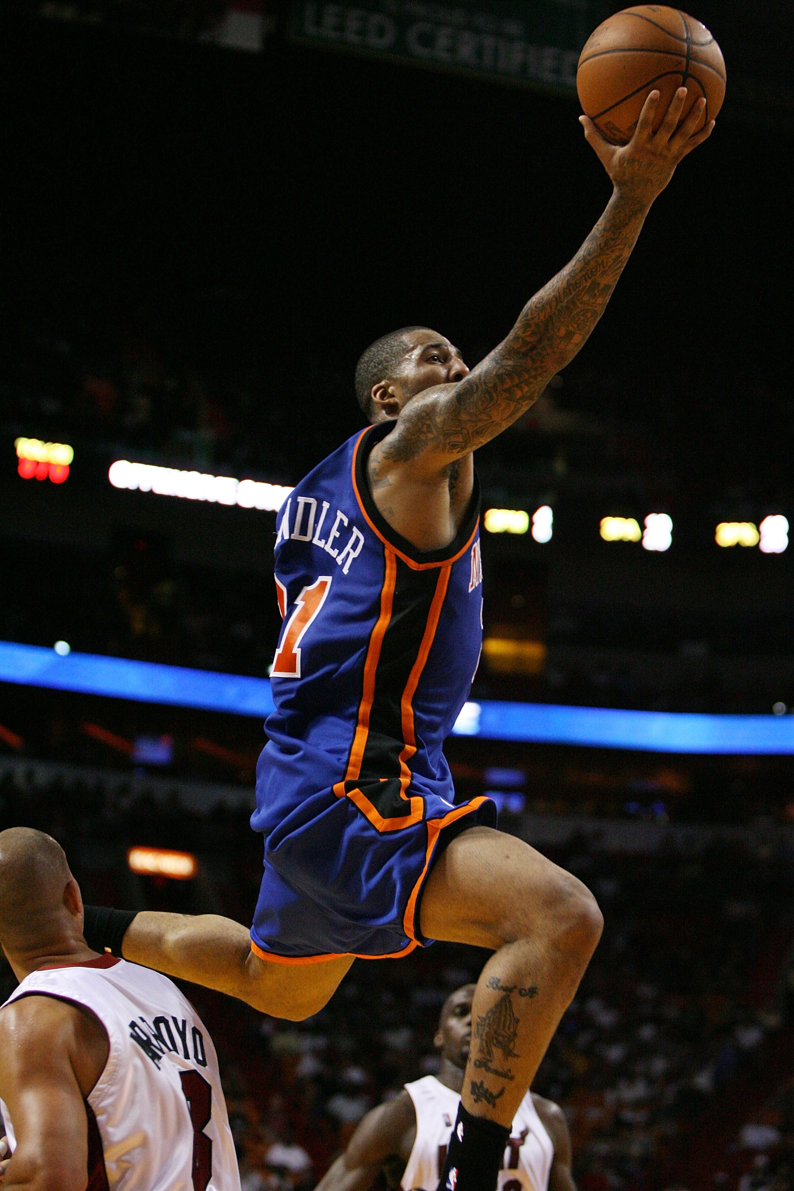 MIAMI - OCTOBER 28:  Wilson Chandler #21 of the New York Knicks jumps over Carlos Arroyo #8 of the Miami Heat at AmericanAirlines Arena on October 28, 2009 in Miami, Florida. The Heat defeated the Knicks 115-93. NOTE TO USER: User expressly acknowledges a