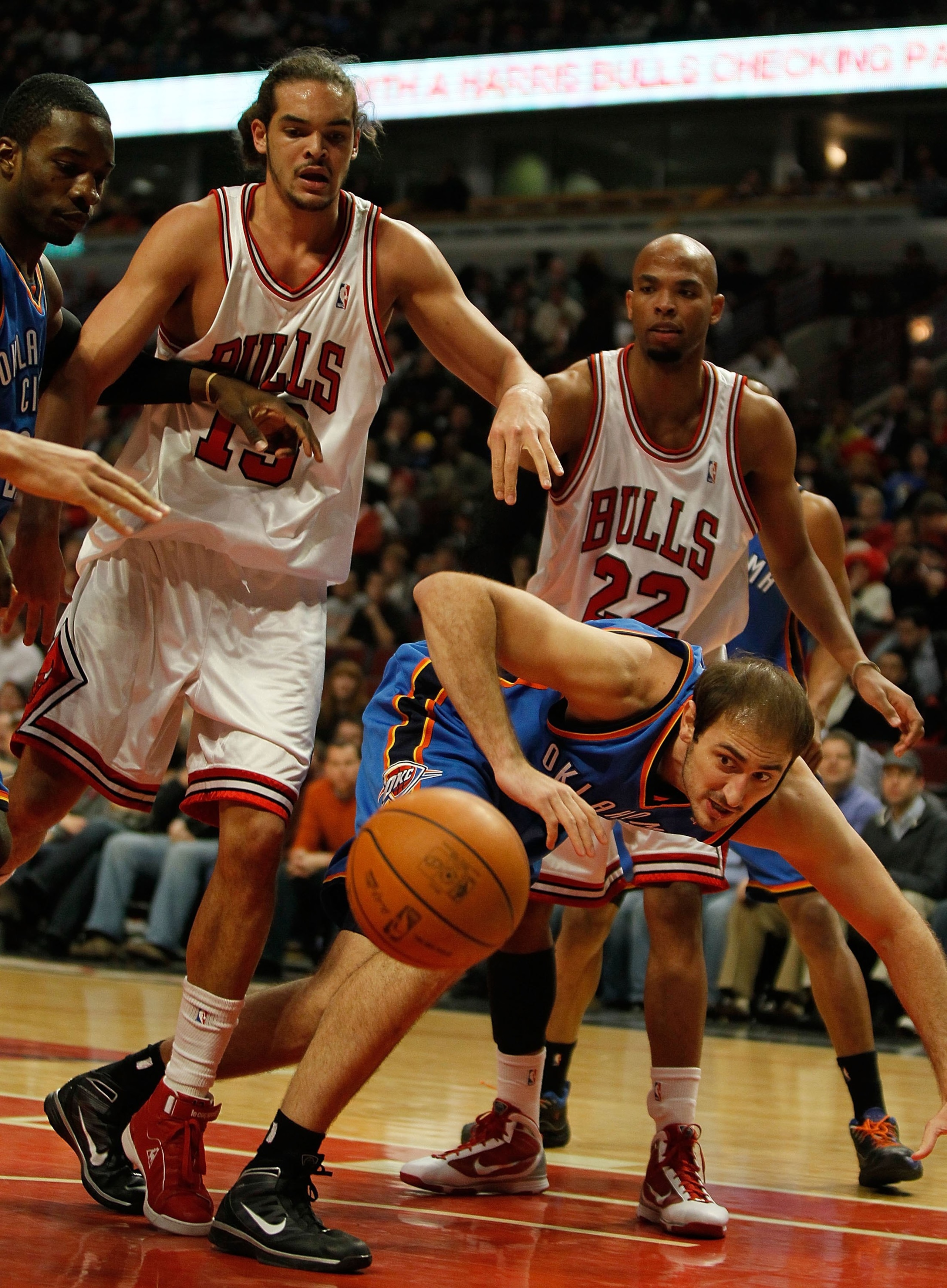 CHICAGO - JANUARY 04: Nenad Krstic #12 of the Oklahoma City Thunder looses the ball under pressure from Joakim Noah #13 and Taj Gibson #22 of the Chicago Bulls at the United Center on January 4, 2010 in Chicago, Illinois. The Thunder defeated the Bulls 98