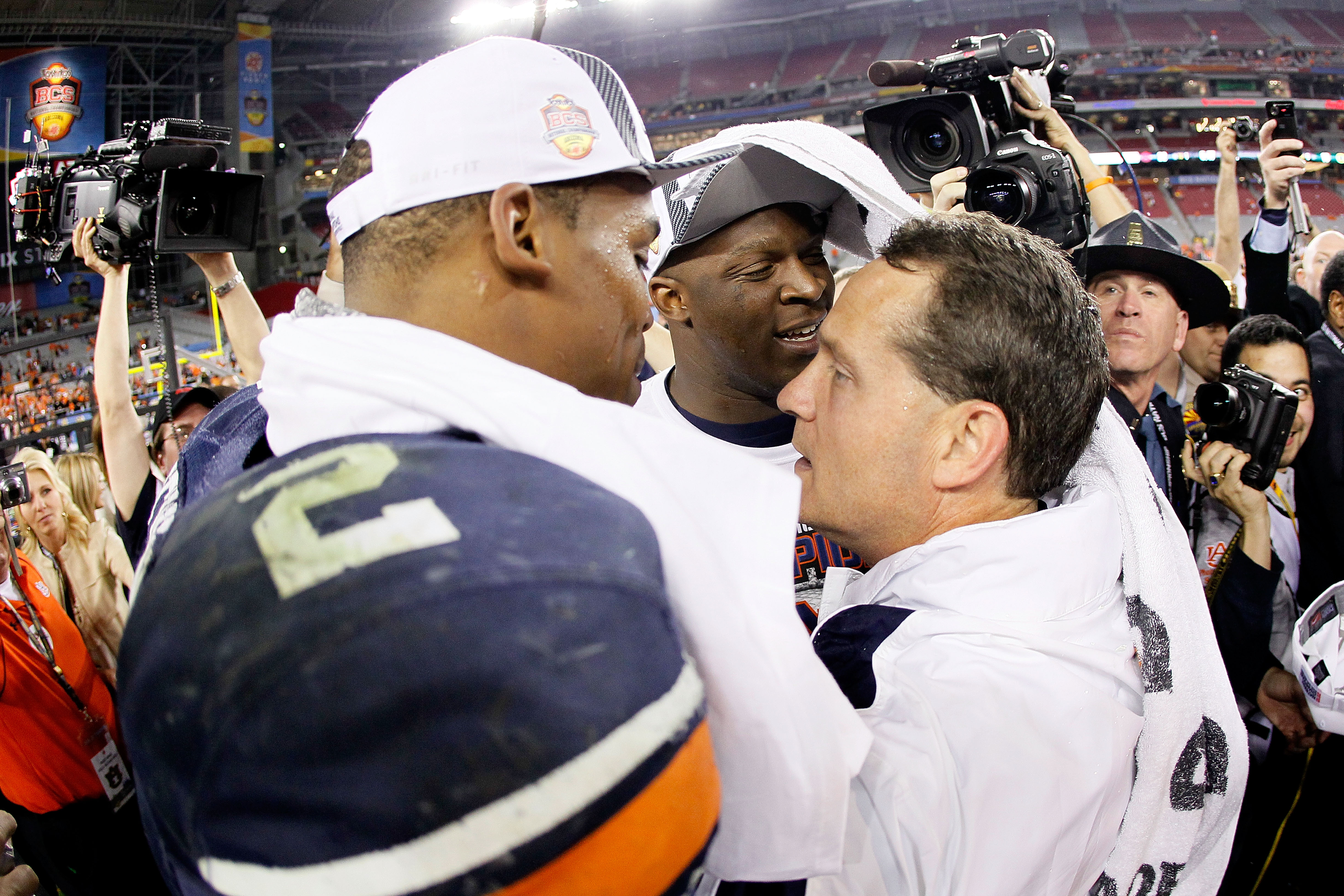 GLENDALE, AZ - JANUARY 10: Quarterback Cameron Newton #2 and head coach Gene Chizik of the Auburn Tigers celebrate the Tigers 22-19 victory with the fans after defeating the Oregon Ducks in the Tostitos BCS National Championship Game at University of Pho GLENDALE, AZ - JANUARY 10: Quarterback Cameron Newton #2 and head coach Gene Chizik of the Auburn Tigers celebrate the Tigers 22-19 victory with the fans after defeating the Oregon Ducks in the Tostitos BCS National Championship Game at University of Pho