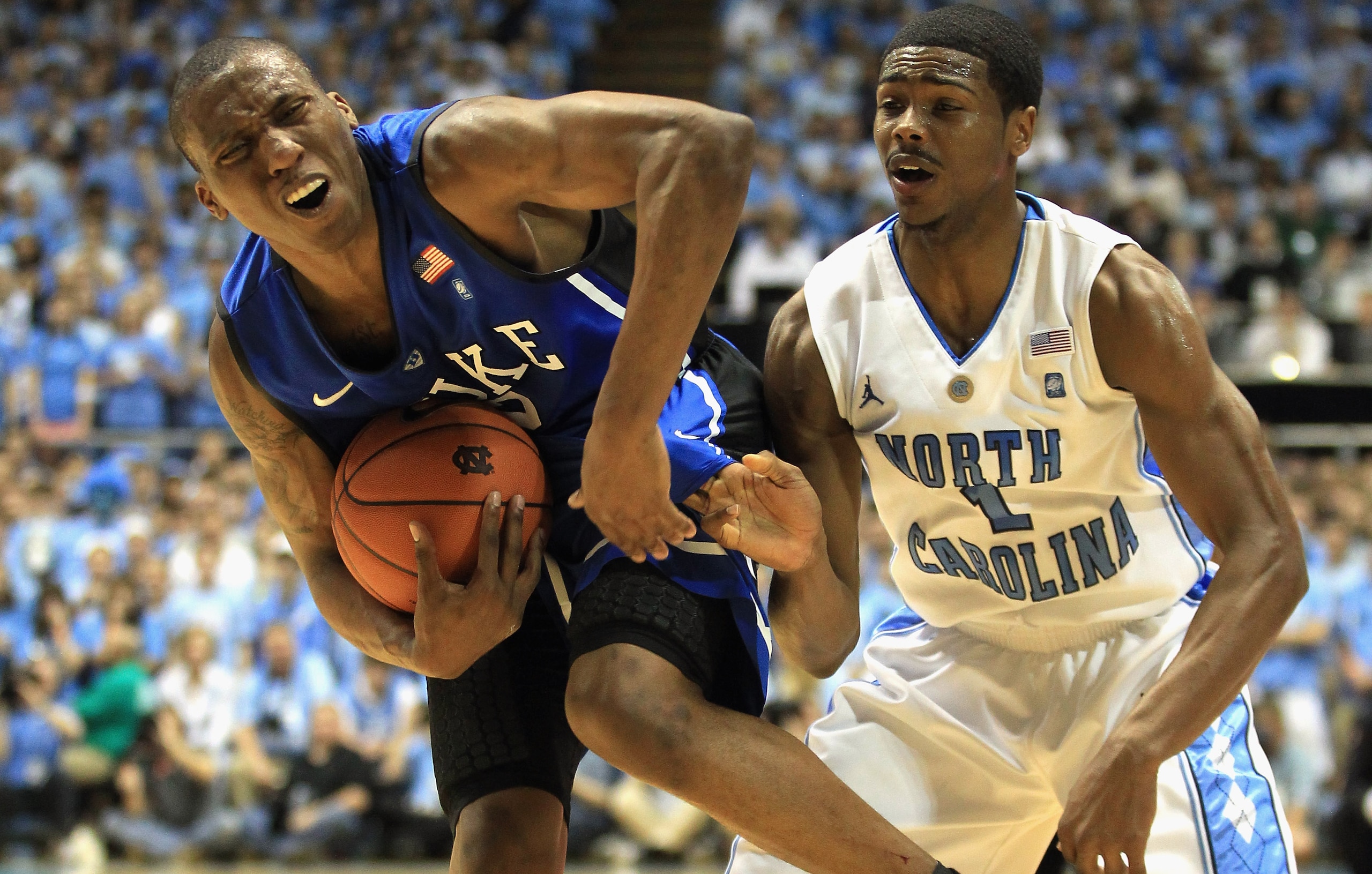 CHAPEL HILL, NC - MARCH 05:  Nolan Smith #2 of the Duke Blue Devils reacts to running into Dexter Strickland #1 of the North Carolina Tar Heels during their game at the Dean E. Smith Center on March 5, 2011 in Chapel Hill, North Carolina.  (Photo by Stree