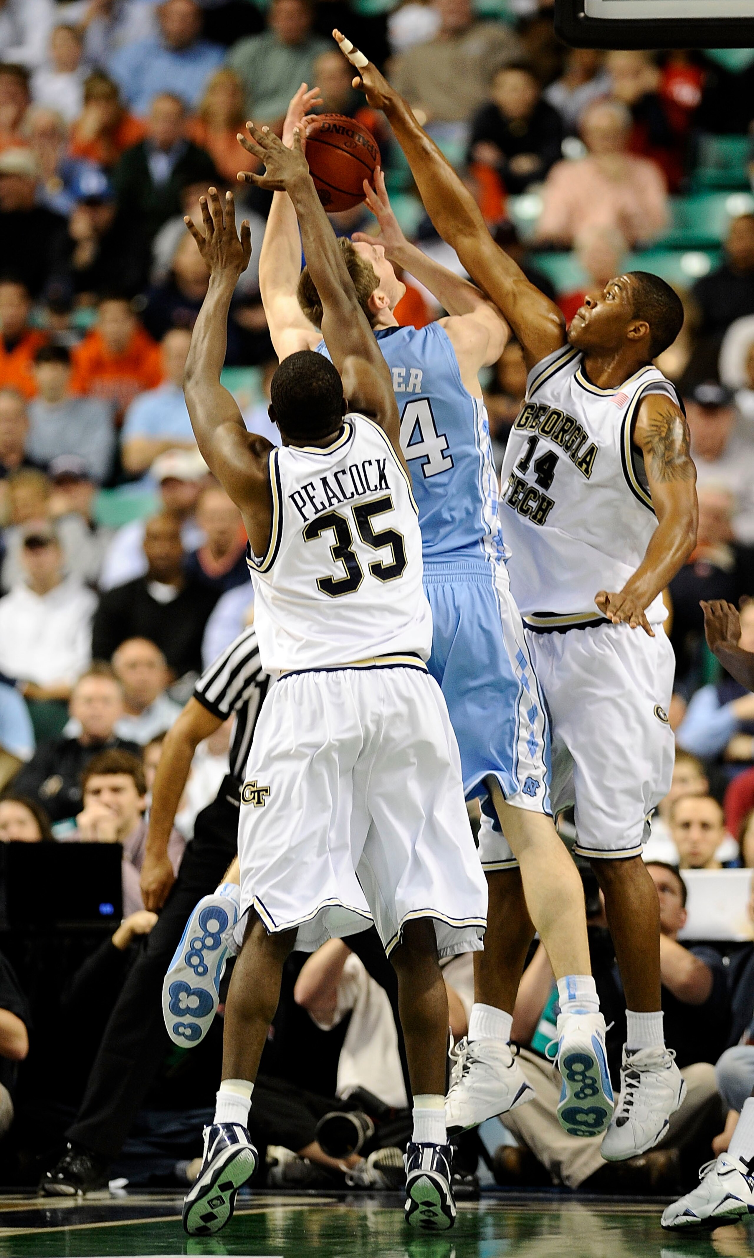 GREENSBORO, NC - MARCH 11:  Zachery Peacock #35 and Derrick Favors #14 of the Georgia Tech Yellow Jackets guard Tyler Zeller #44 of the University of the North Carolina Tarheels in their first round game in the 2010 ACC Men's Basketball Tournament at the
