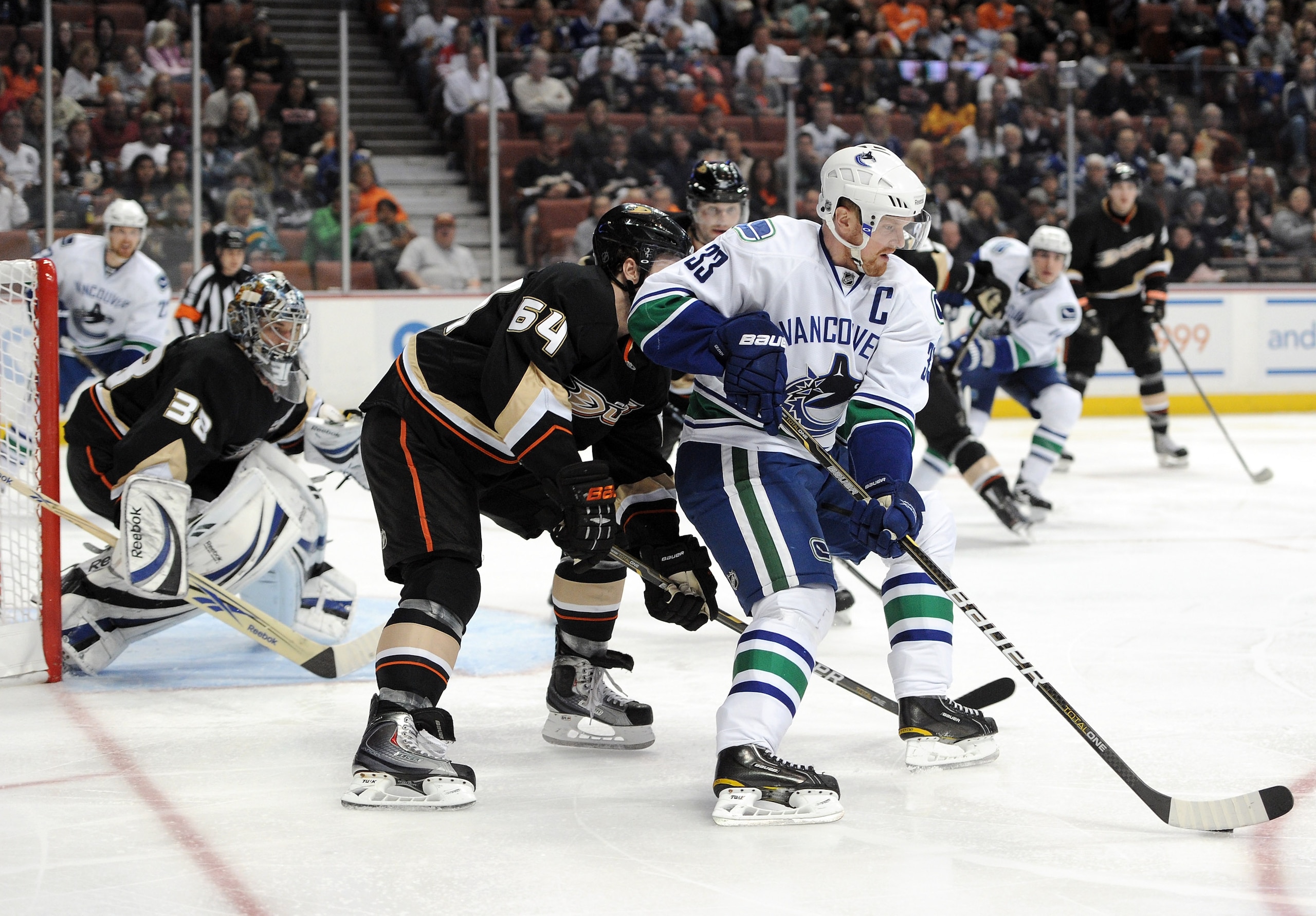 ANAHEIM, CA - MARCH 06:  Henrik Sedin #33 of the Vancouver Canucks positions himself for a shot in front of Brandon McMillan #64 of the Anaheim Ducks at the Honda Center on March 6, 2011 in Anaheim, California.  (Photo by Harry How/Getty Images)