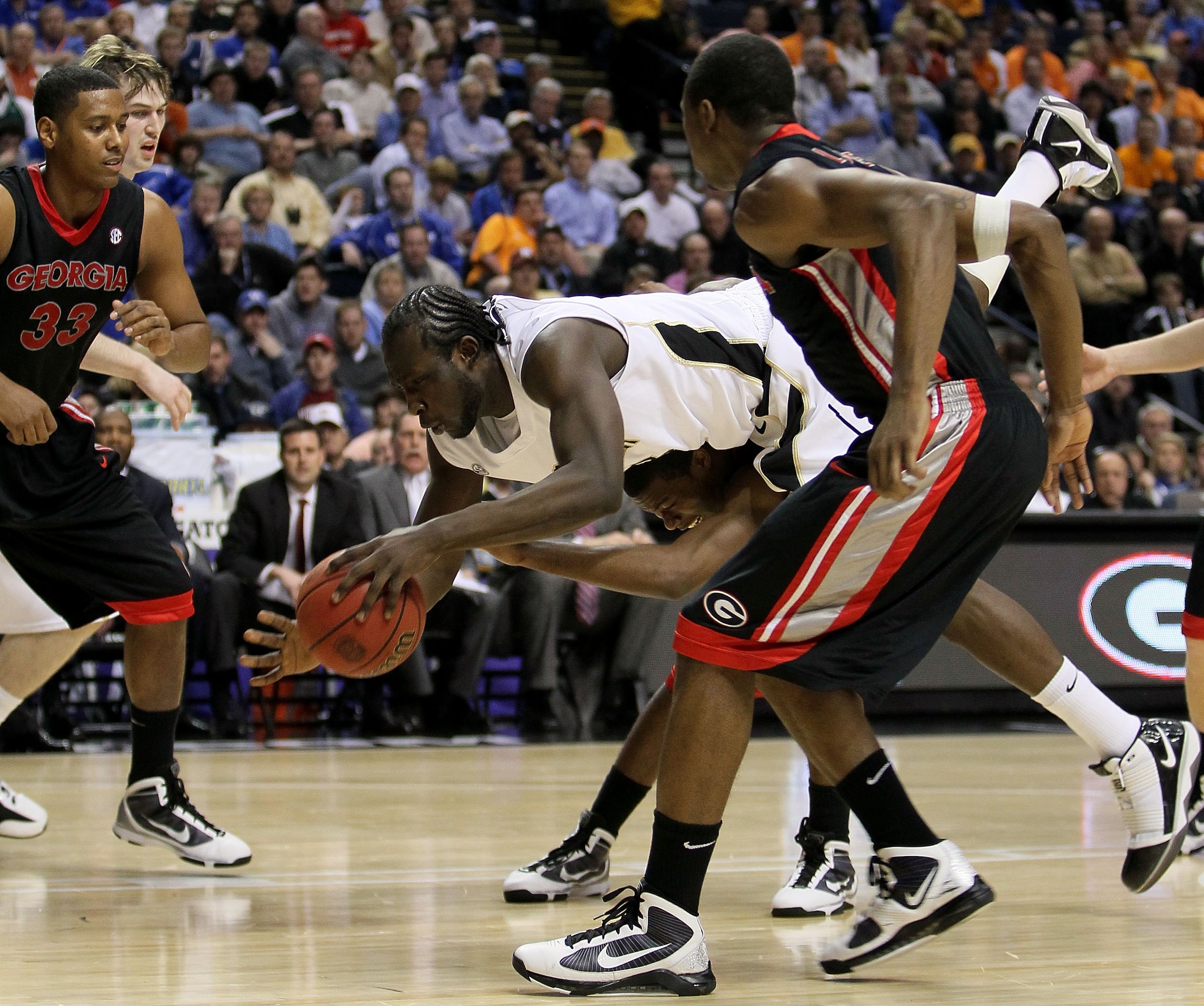 NASHVILLE, TN - MARCH 12:  Steve Tchiengang #33 of the Vanderbilt Commodores attempts to control the ball as he falls against the Georgia Bulldogs during the quarterfinals of the SEC Men's Basketball Tournament at the Bridgestone Arena on March 12, 2010 i