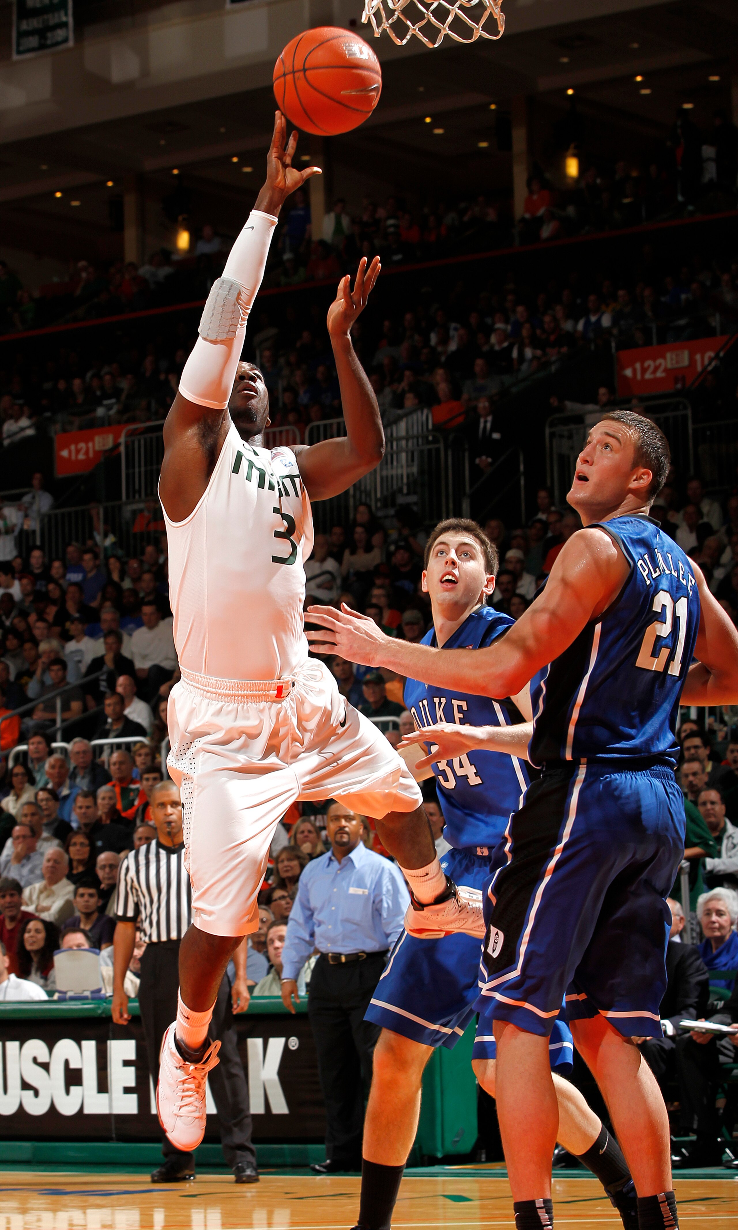CORAL GABLES, FL - FEBRUARY 13: Malcolm Grant #3 of the Miami Hurricanes scores past Miles Plumlee #21 of the Duke Blue Devils on February 13, 2011 at the BankUnited Center in Coral Gables, Florida. (Photo by Joel Auerbach/Getty Images)
