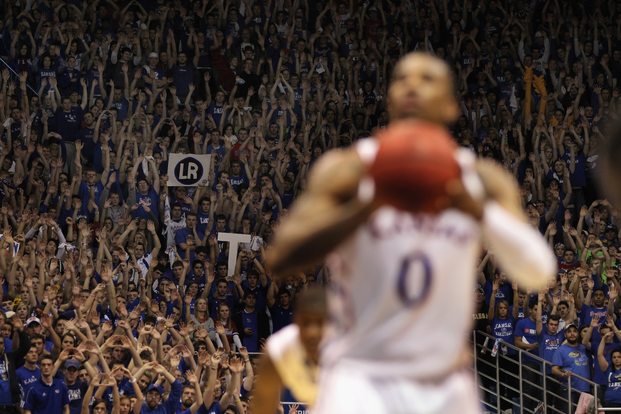LAWRENCE, KS - JANUARY 29: A fan holds up a sign depicting the initials of his late mother as Thomas Robinson #0 of the Kansas Jayhawks shoots a free throw during the game against the Kansas State Wildcats on January 29, 2011 at Allen Fieldhouse in Lawre LAWRENCE, KS - JANUARY 29: A fan holds up a sign depicting the initials of his late mother as Thomas Robinson #0 of the Kansas Jayhawks shoots a free throw during the game against the Kansas State Wildcats on January 29, 2011 at Allen Fieldhouse in Lawre
