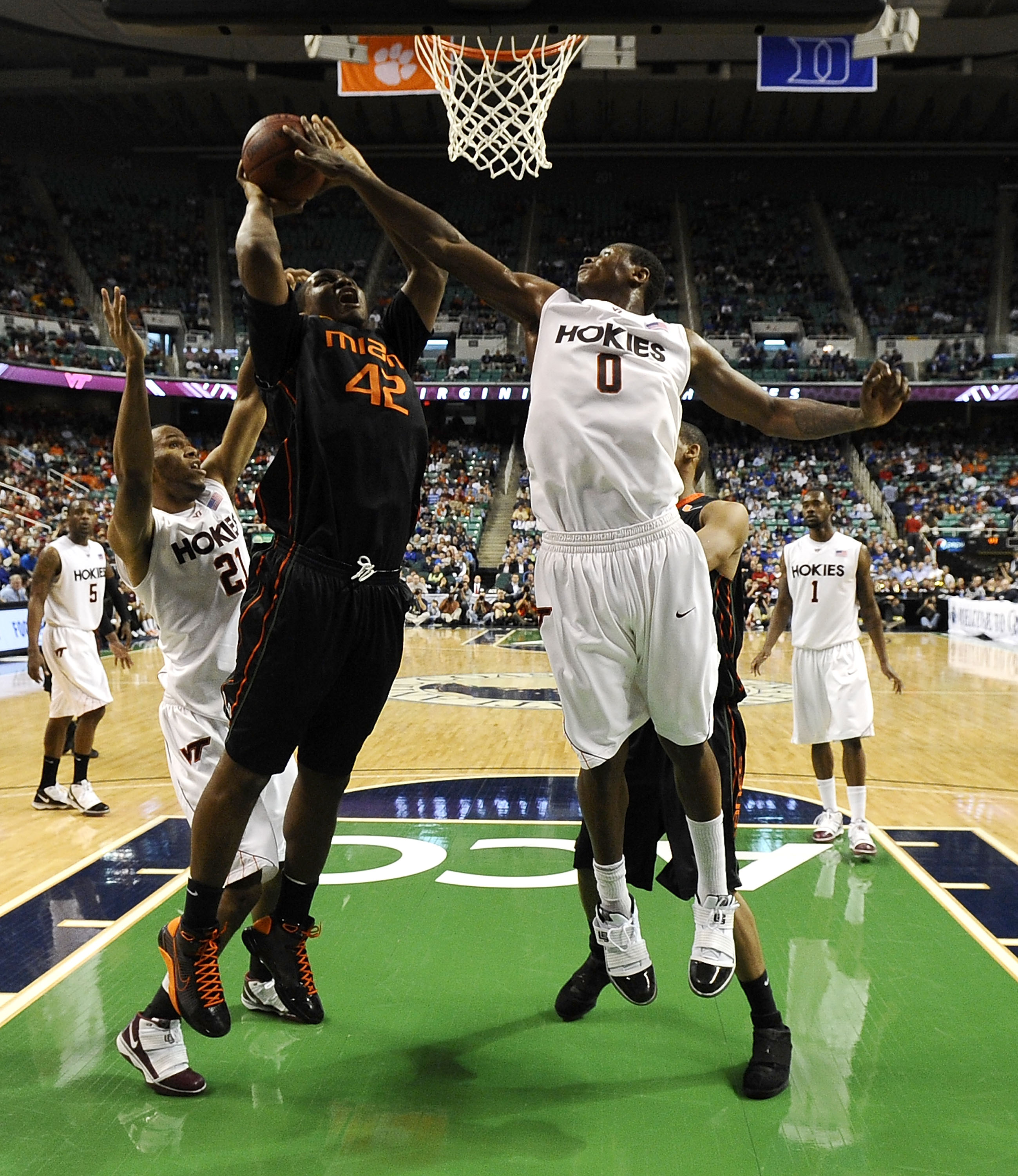 GREENSBORO, NC - MARCH 12:  Jeff Allen #00 of the Virginia Tech Hokies defends  Reggie Johnson #42 of the University of Miami Hurricanes in their quarterfinal game in the 2010 ACC Men's Basketball Tournament at the Greensboro Coliseum on March 12, 2010 in