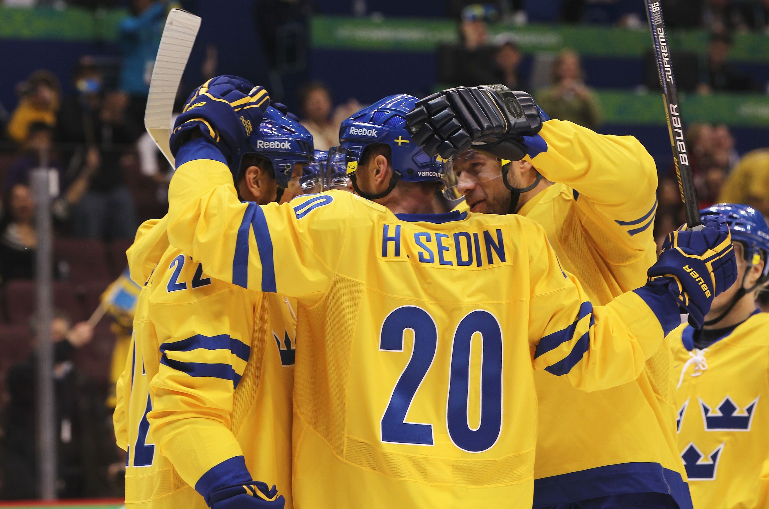 VANCOUVER, BC - FEBRUARY 19:  Henrik Sedin #20 of Sweden and teammates celebrate the goal scored by Daniel Alfredsson #11 against Belarus during the ice hockey men's preliminary game on day 8 of the Vancouver 2010 Winter Olympics at Canada Hockey Place on