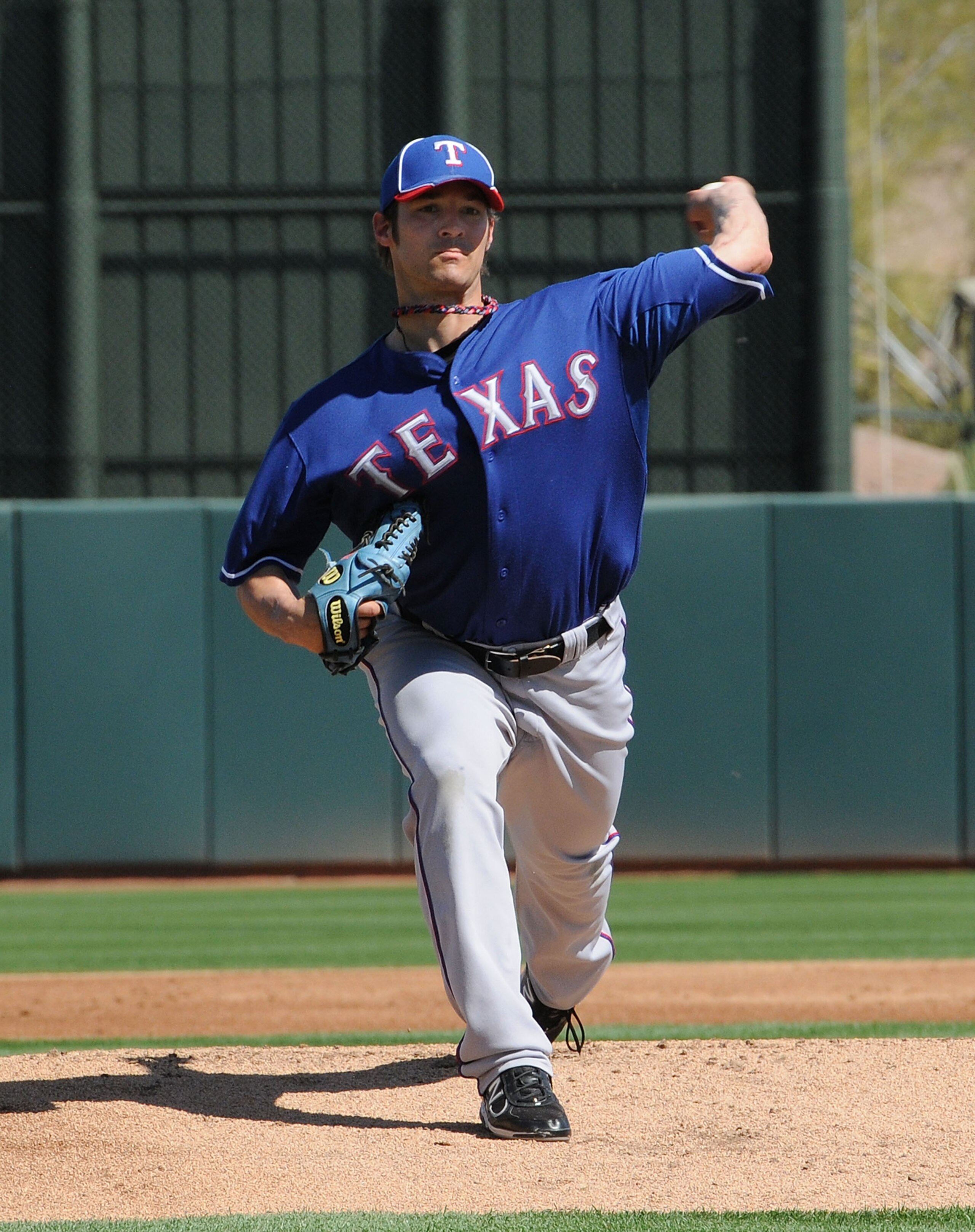 PHOENIX, AZ - MARCH 04:  C.J. Wilson #36 of the Texas Rangers delivers a pitch against the Oakland Athletics at Phoenix Municipal Stadium on March 4, 2011 in Phoenix, Arizona.  (Photo by Norm Hall/Getty Images)