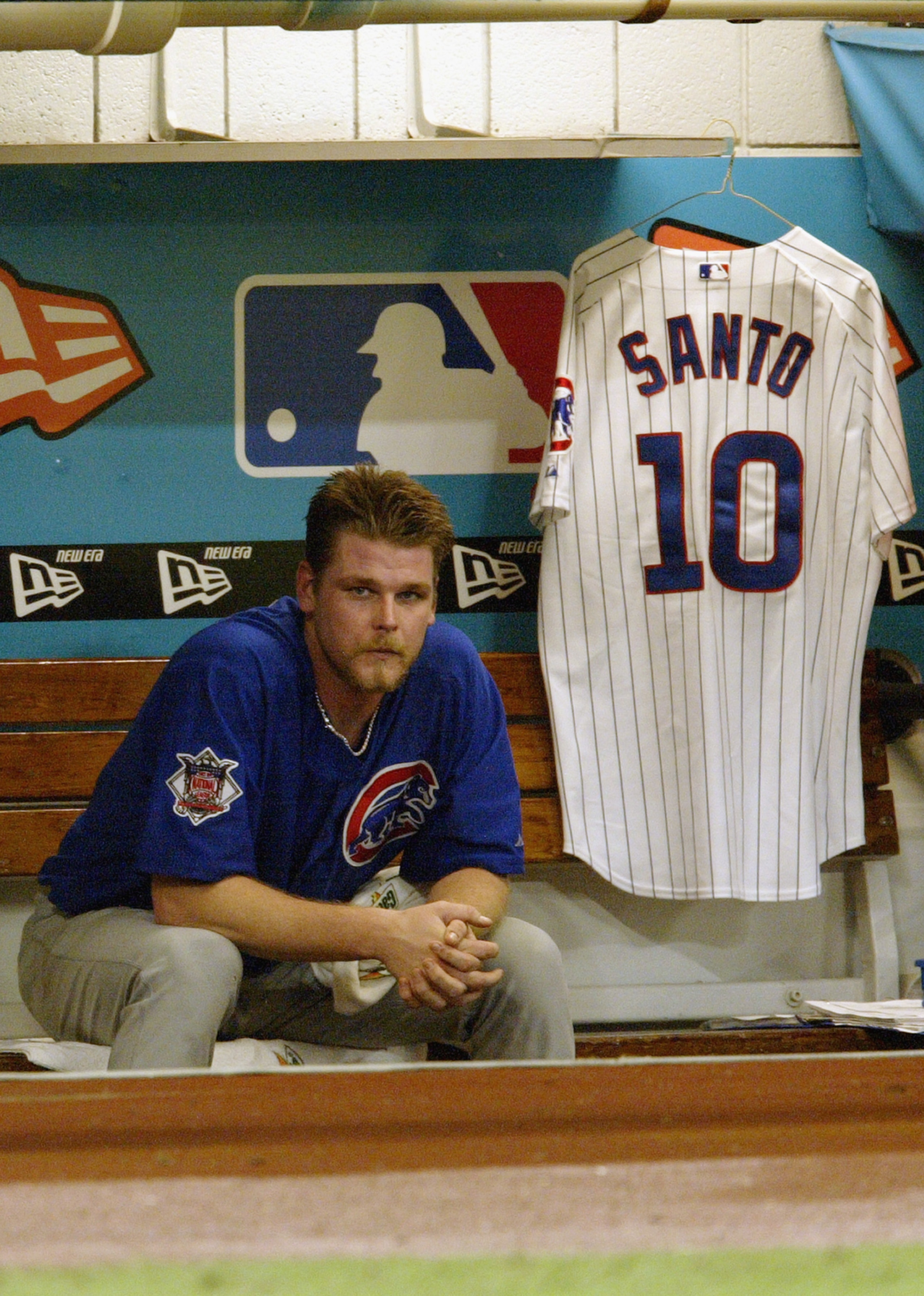 MIAMI - OCTOBER 10:  Kerry Wood #34 of the Chicago Cubs watches game three of the National League Championship Series against the Florida Marlins from the dugout as a uniform of Cub great Ron Santo #10 hangs beside him on October 10, 2003 at Pro Player St
