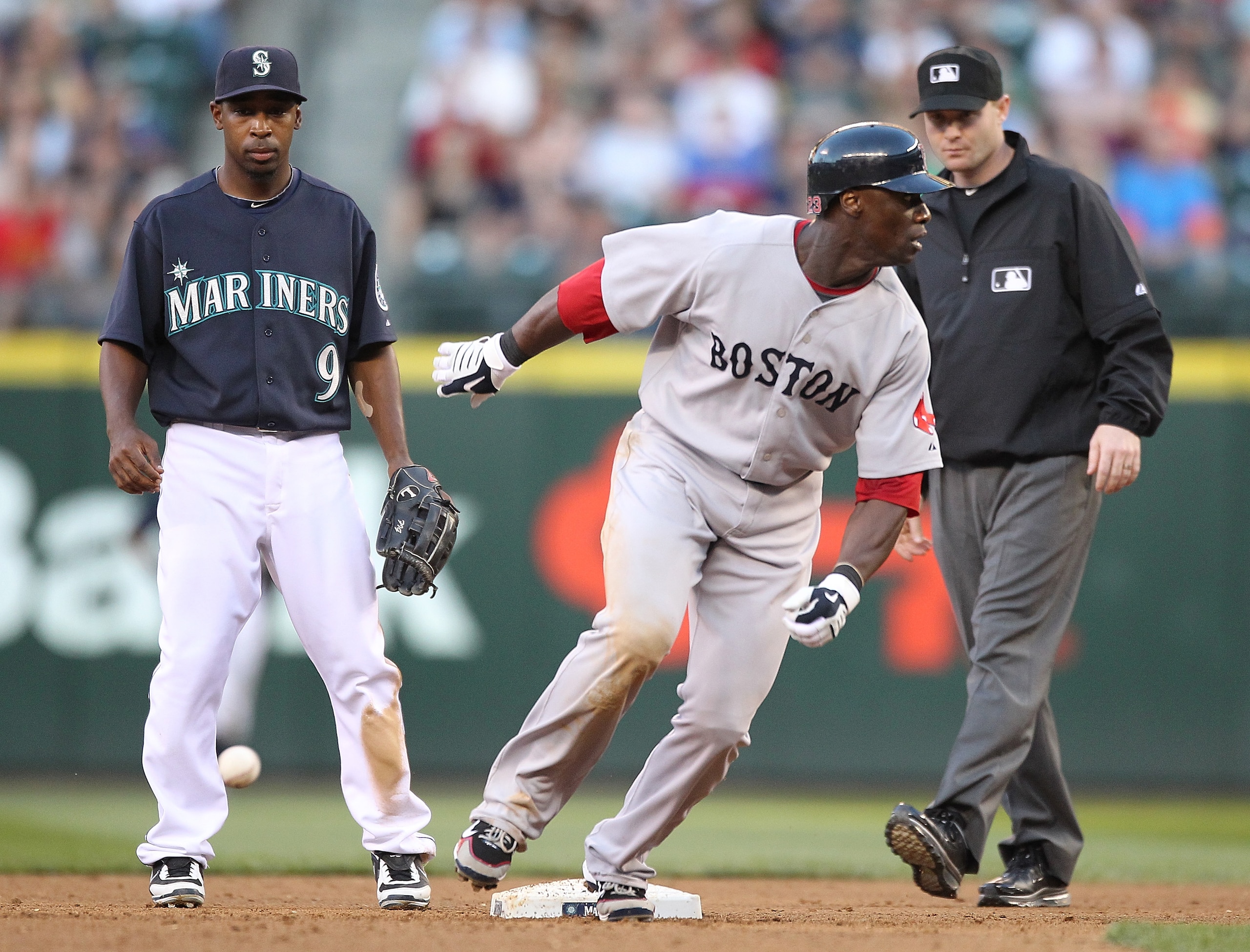 SEATTLE - JULY 23:  Second baseman Chone Figgins #9 of the Seattle Mariners watches the throw from left fielder Michael Saunders bounce past second base as Mike Cameron #23 of the Boston Red Sox advances to third base in the fifth inning at Safeco Field o