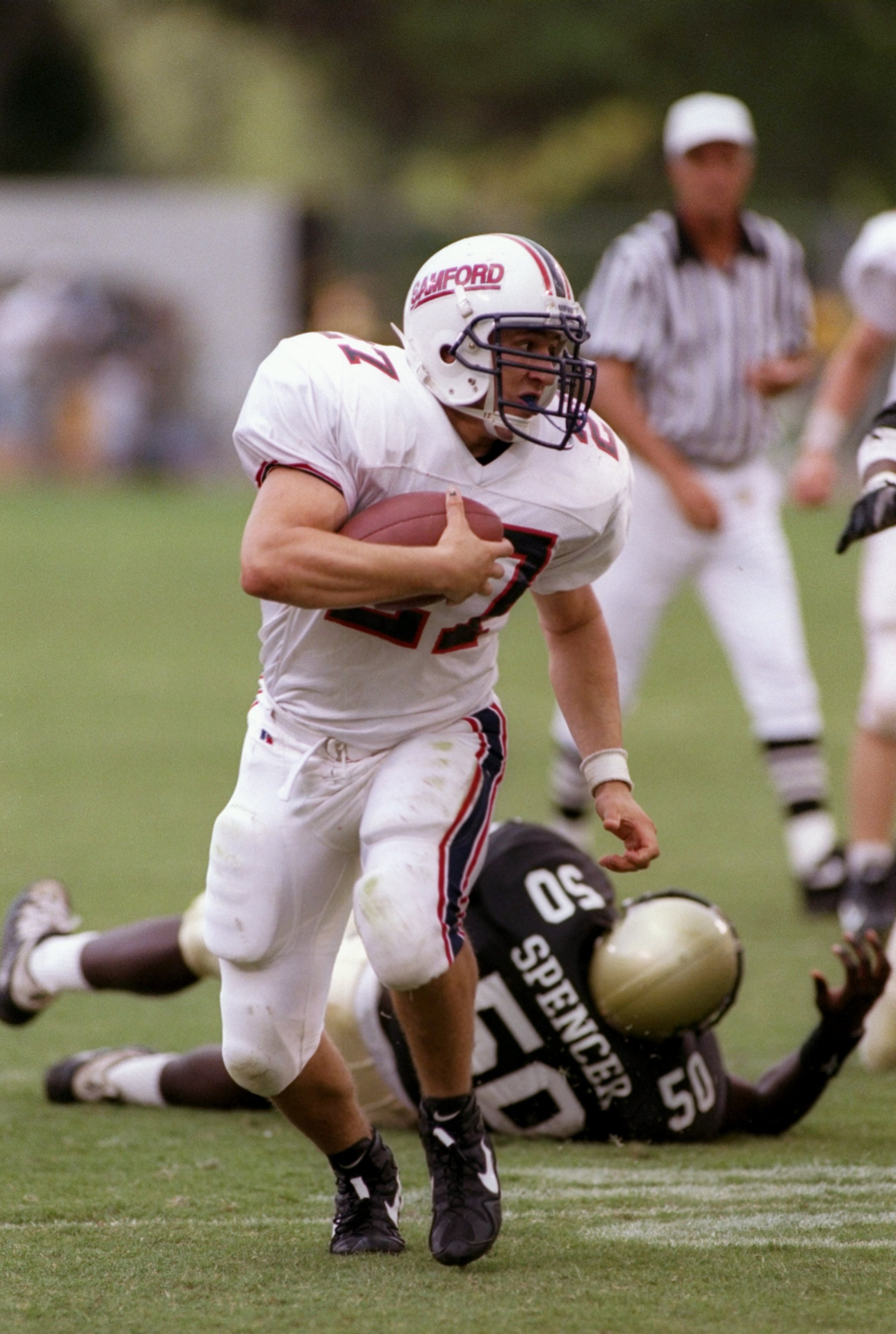 11 Oct 1997:  Jim Whaley of the Samford Bulldogs runs with the ball as linebacker Mike Spencer of the Central Florida Knights lies on the ground behind him during a game at the Florida Citrus Bowl in Orlando, Florida.  Central Florida won the game 52-7.