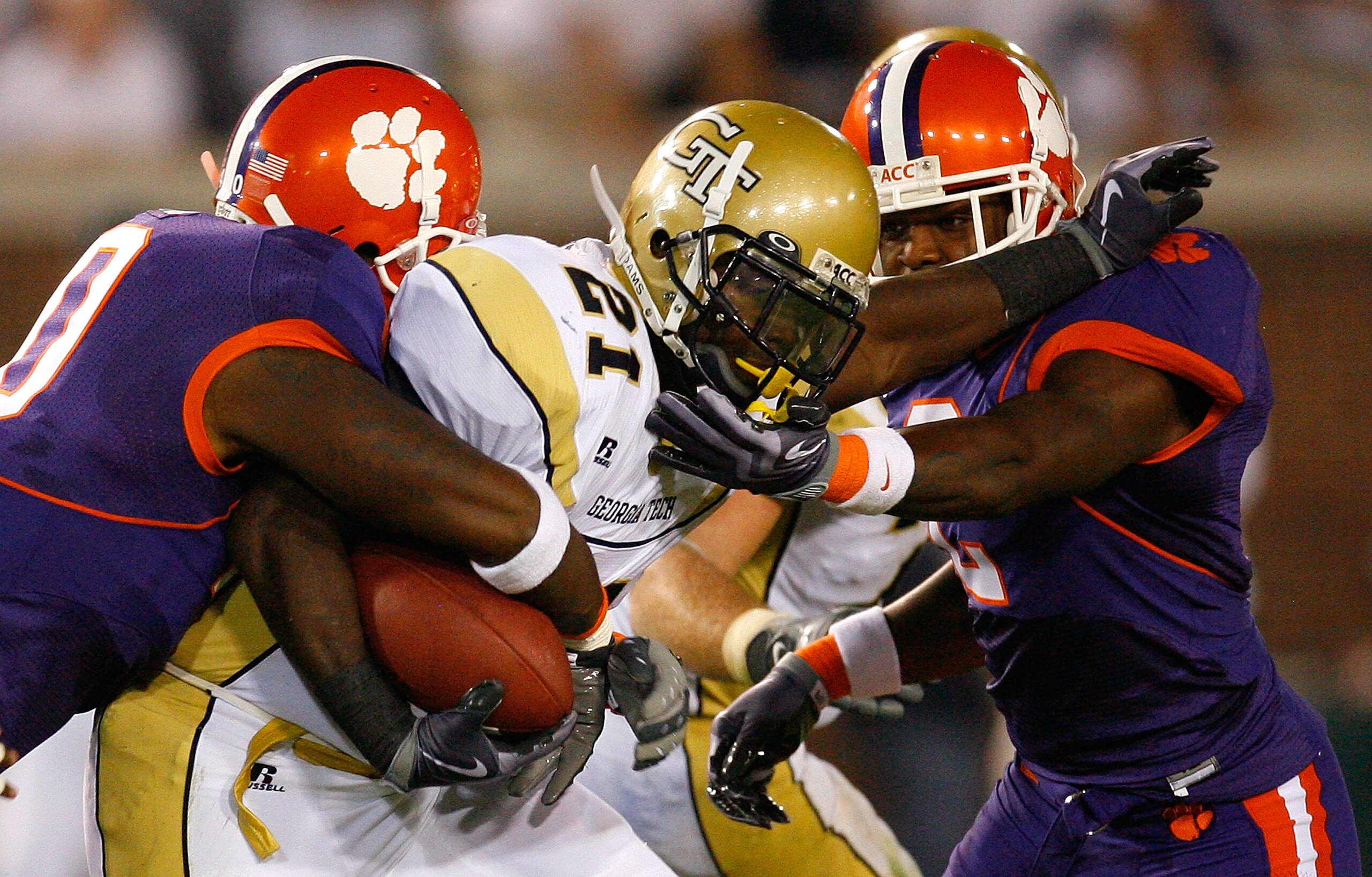 ATLANTA - SEPTEMBER 10:  Running back Jonathan Dwyer #21 of the Georgia Tech Yellow Jackets rushes upfield against Andre Branch #40 and DeAndre McDaniel #2 of the Clemson Tigers at Bobby Dodd Stadium on September 10, 2009 in Atlanta, Georgia.  (Photo by K
