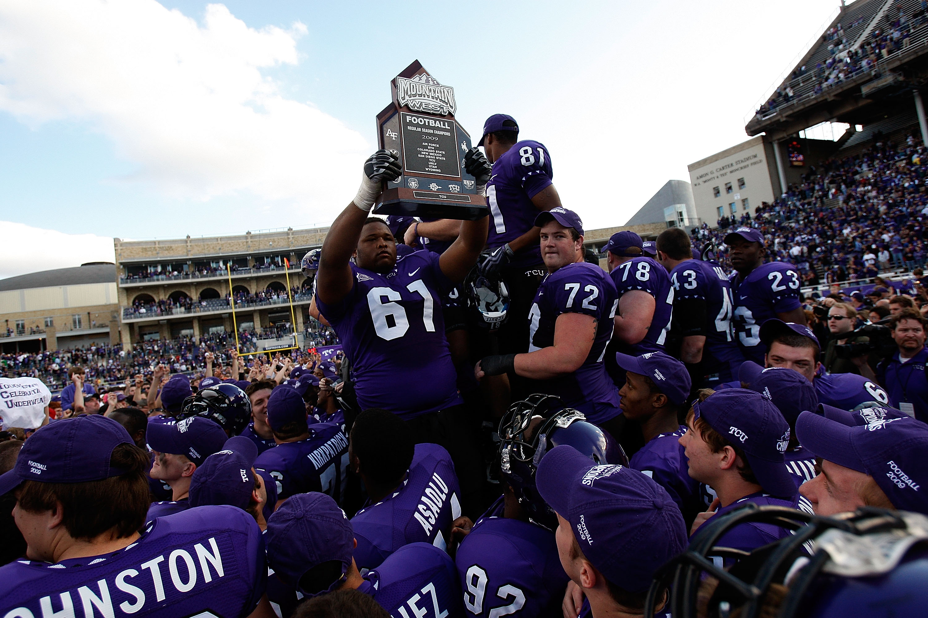 FORT WORTH, TX - NOVEMBER 28:  Marcus Cannon #61, Kyle Dooley #72 and Alonzo Adams #81 of the TCU Horned Frogs raise the Mountain West Regular Season Championship trophy at Amon G. Carter Stadium on November 28, 2009 in Fort Worth, Texas.  (Photo by Ronal