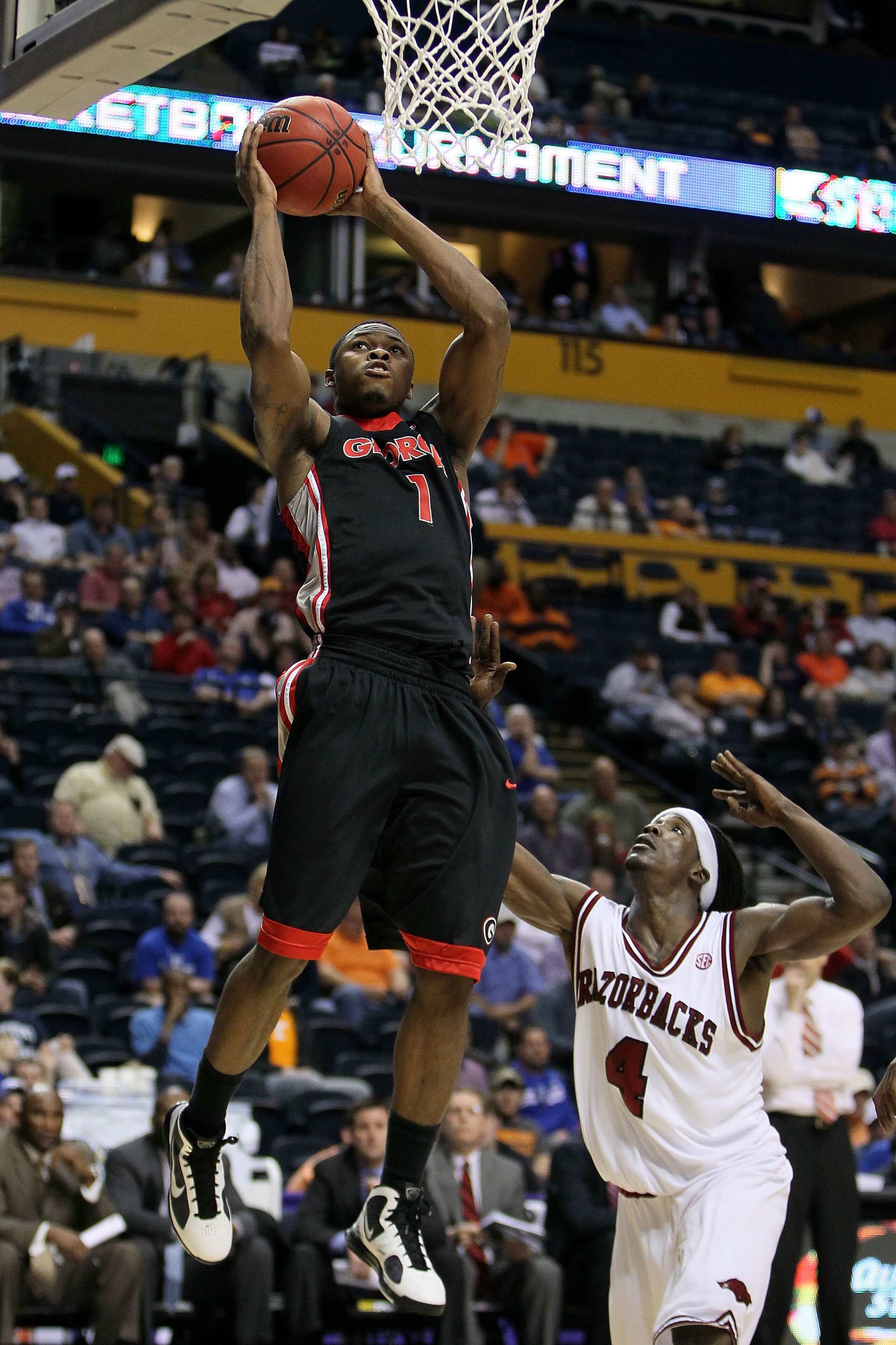 NASHVILLE, TN - MARCH 11:  Travis Leslie #1 of the Georgia Bulldogs attempts a shot against Courtney Fortson #4 of the Arkanasas Razorbacks during the first round of the SEC Men's Basketball Tournament at the Bridgestone Arena on March 11, 2010 in Nashvil