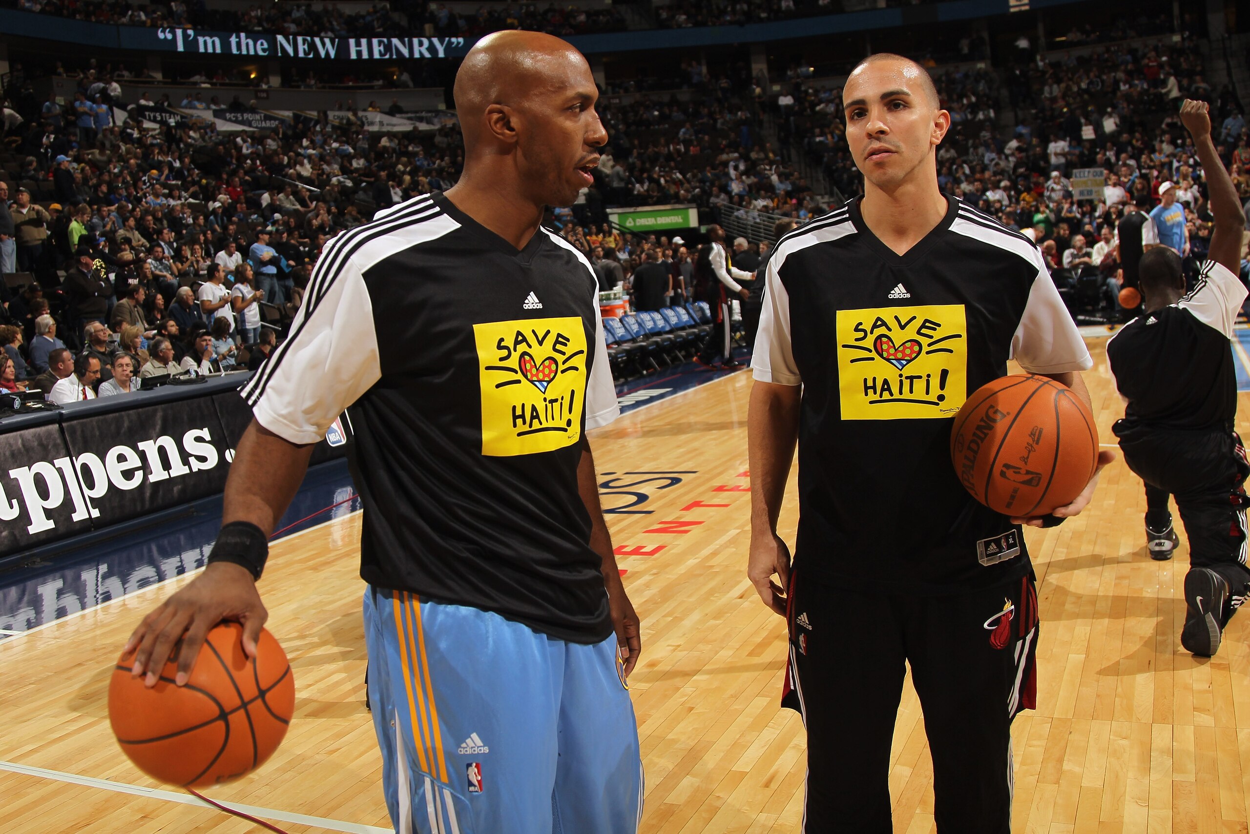 DENVER, CO - JANUARY 13:  (L-R) Chauncey Billups #1 of the Denver Nuggets and Carlos Arroyo #8 of the Miami Heat talk during pregame as the teams warmed up in 'Save Haiti' shirts to promote the Haiti Relief Fund at the Pepsi Center on January 13, 2011 in
