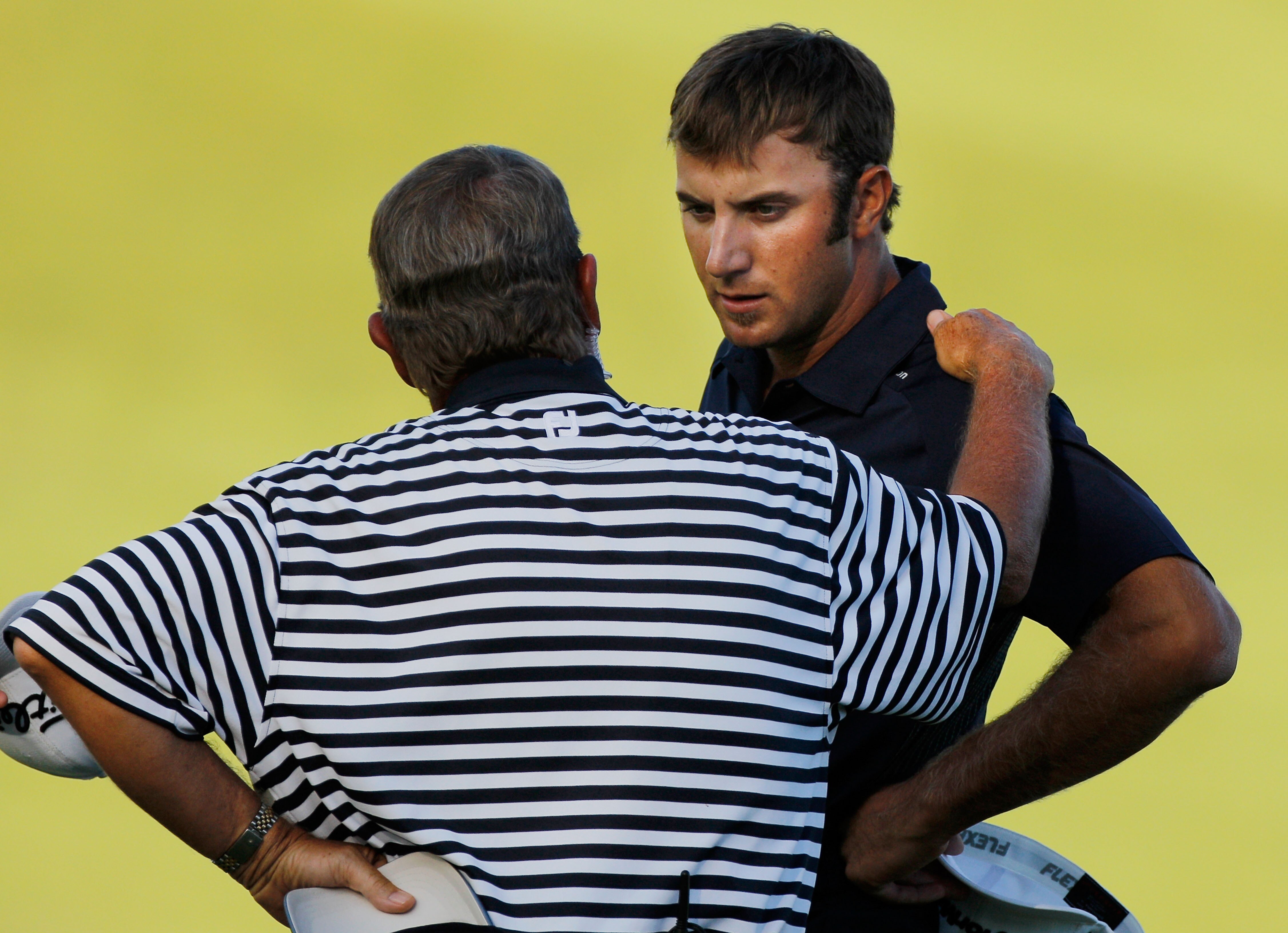 KOHLER, WI - AUGUST 15:  A PGA of America rules official chats with Dustin Johnson (R) on the 18th green during the final round of the 92nd PGA Championship on the Straits Course at Whistling Straits on August 15, 2010 in Kohler, Wisconsin.  (Photo by Sam