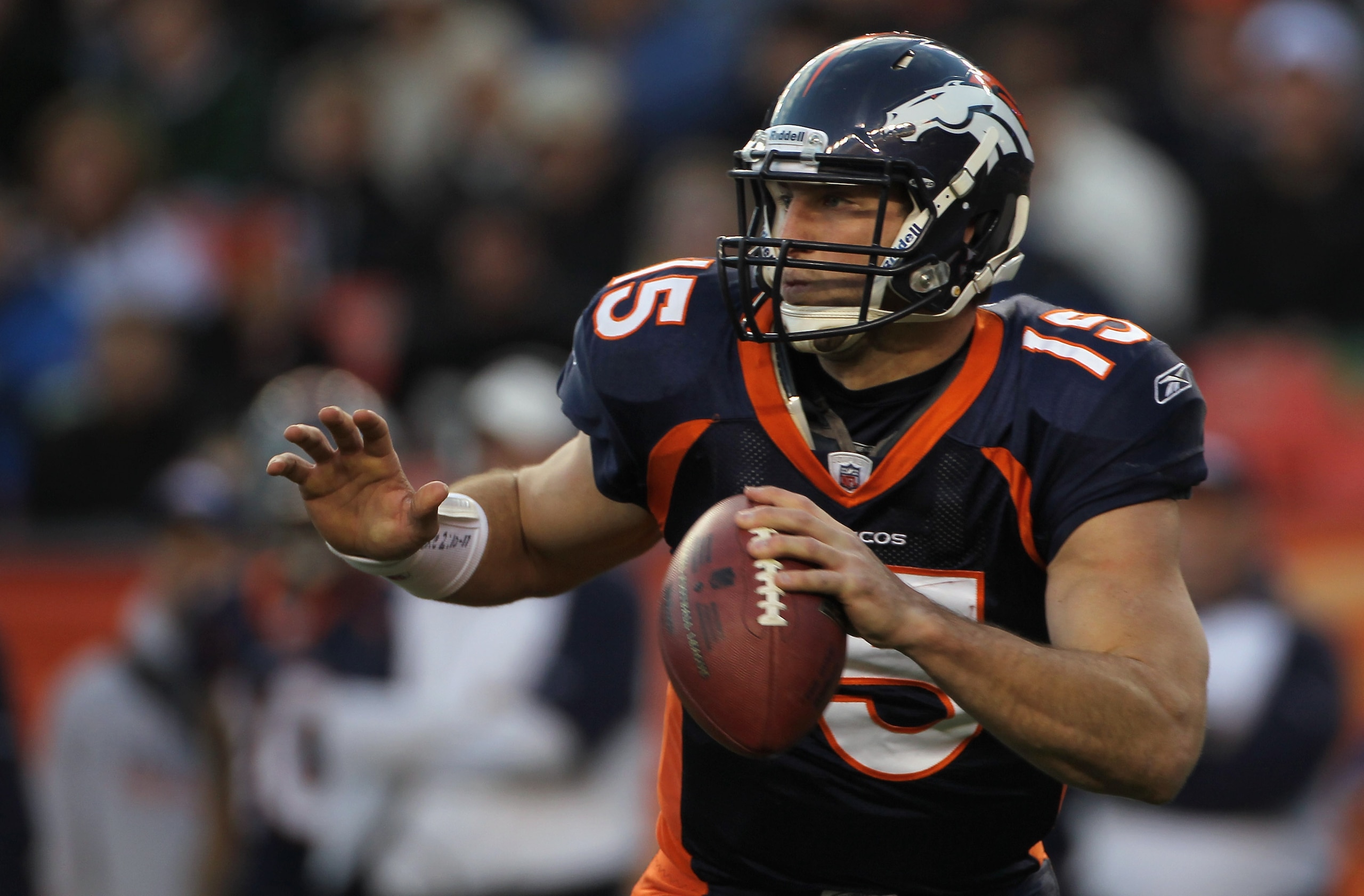 DENVER - DECEMBER 26:  Quarterback Tim Tebow #15 of the Denver Broncos rolls out and looks to deliver a pass against the Houston Texas at INVESCO Field at Mile High on December 26, 2010 in Denver, Colorado. The Broncos defeated the Texans 24-23.  (Photo b