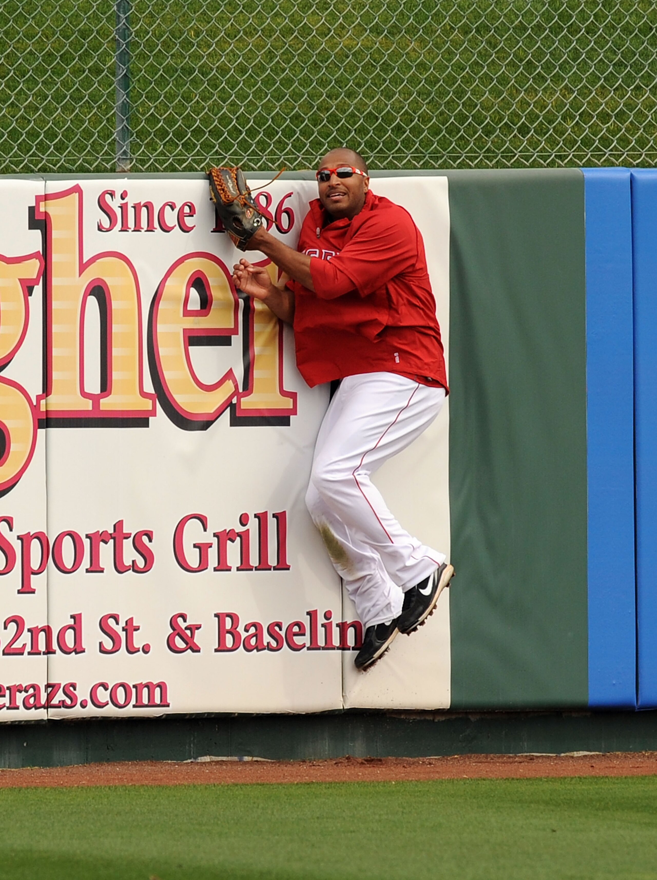 TEMPE, AZ - FEBRUARY 26:  Vernon Wells #10 of the Los Angeles Angels of Anaheim leaps into the outfield wall to catch a batting practice fly ball prior to the Los Angeles Dodgers game at Tempe Diablo Stadium on February 26, 2011 in Tempe, Arizona.  (Photo