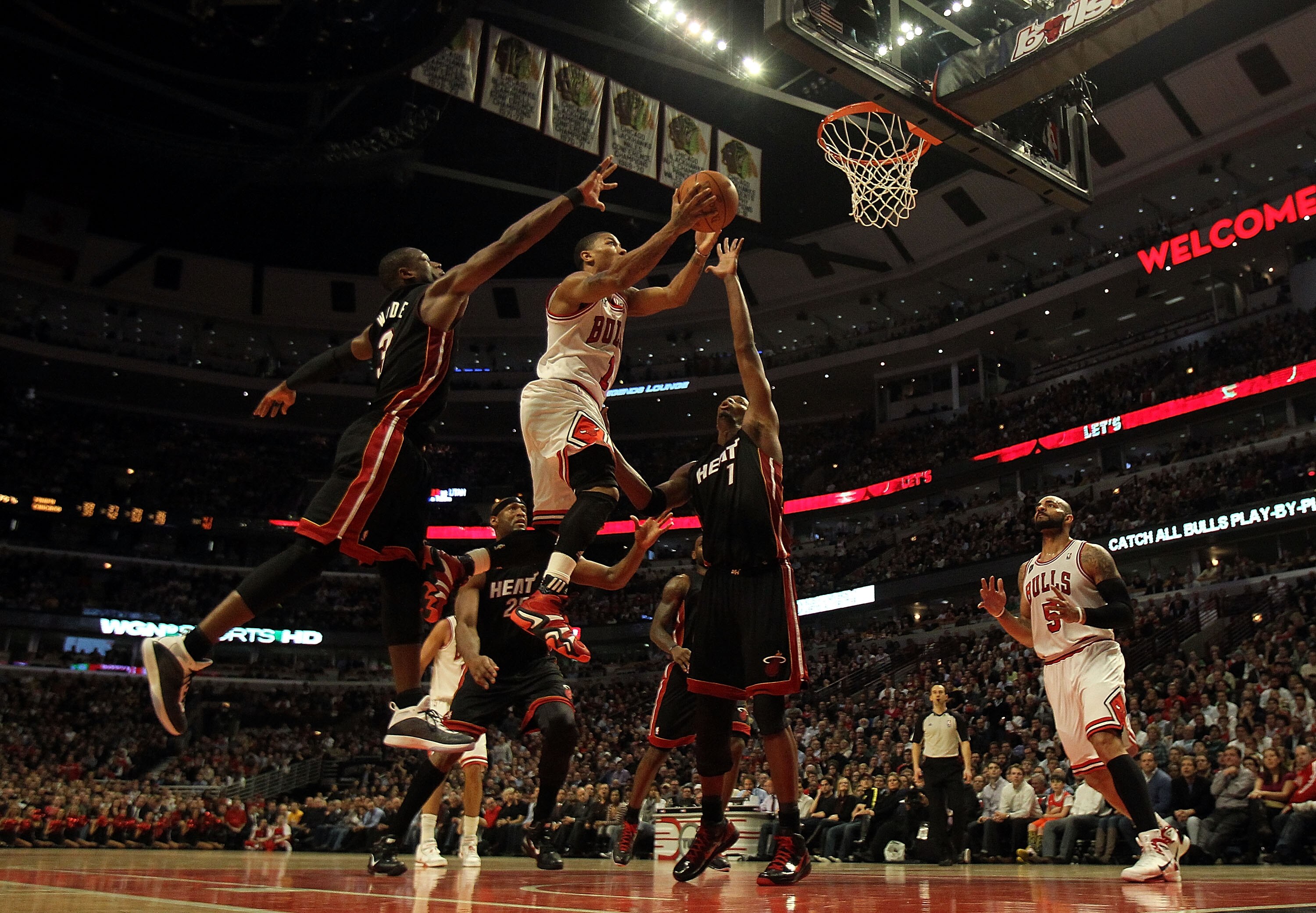 CHICAGO, IL - FEBRUARY 24: Derrick Rose #1 of the Chicago Bulls puts up a shot between Dwyane Wade #3 and Chris Bosh #1 of the Miami Heat at the United Center on February 24, 2011 in Chicago, Illinois. The Bulls defeated the Heat 93-89. NOTE TO USER: User