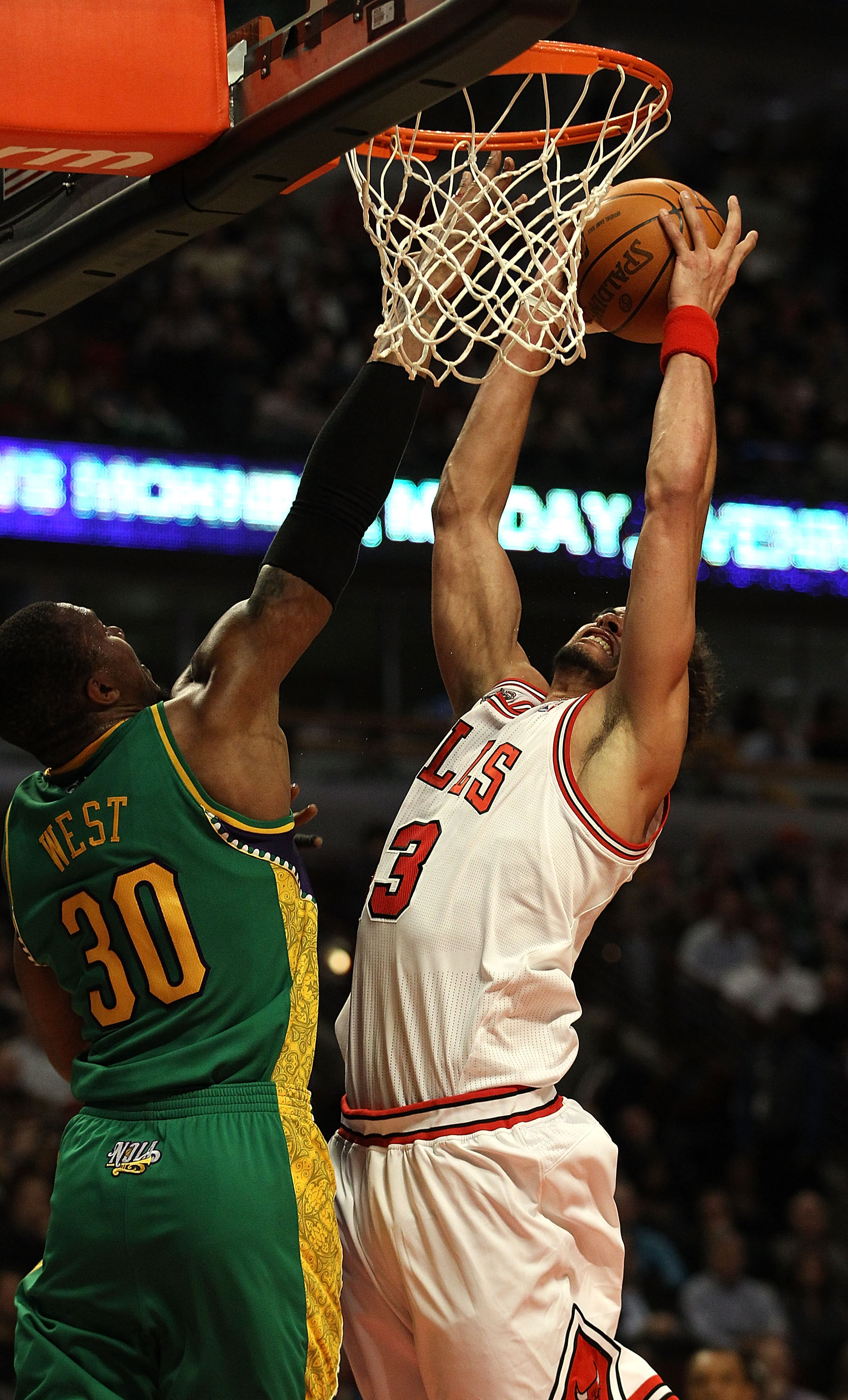 CHICAGO, IL - MARCH 07: Joakim Noah #13 of the Chicago Bulls grabs a rebound over David West #30 of the New Orleans Hornets at the United Center on March 7, 2011 in Chicago, Illinois. The Bulls defeated the Hornets 85-77. NOTE TO USER: User expressly ackn