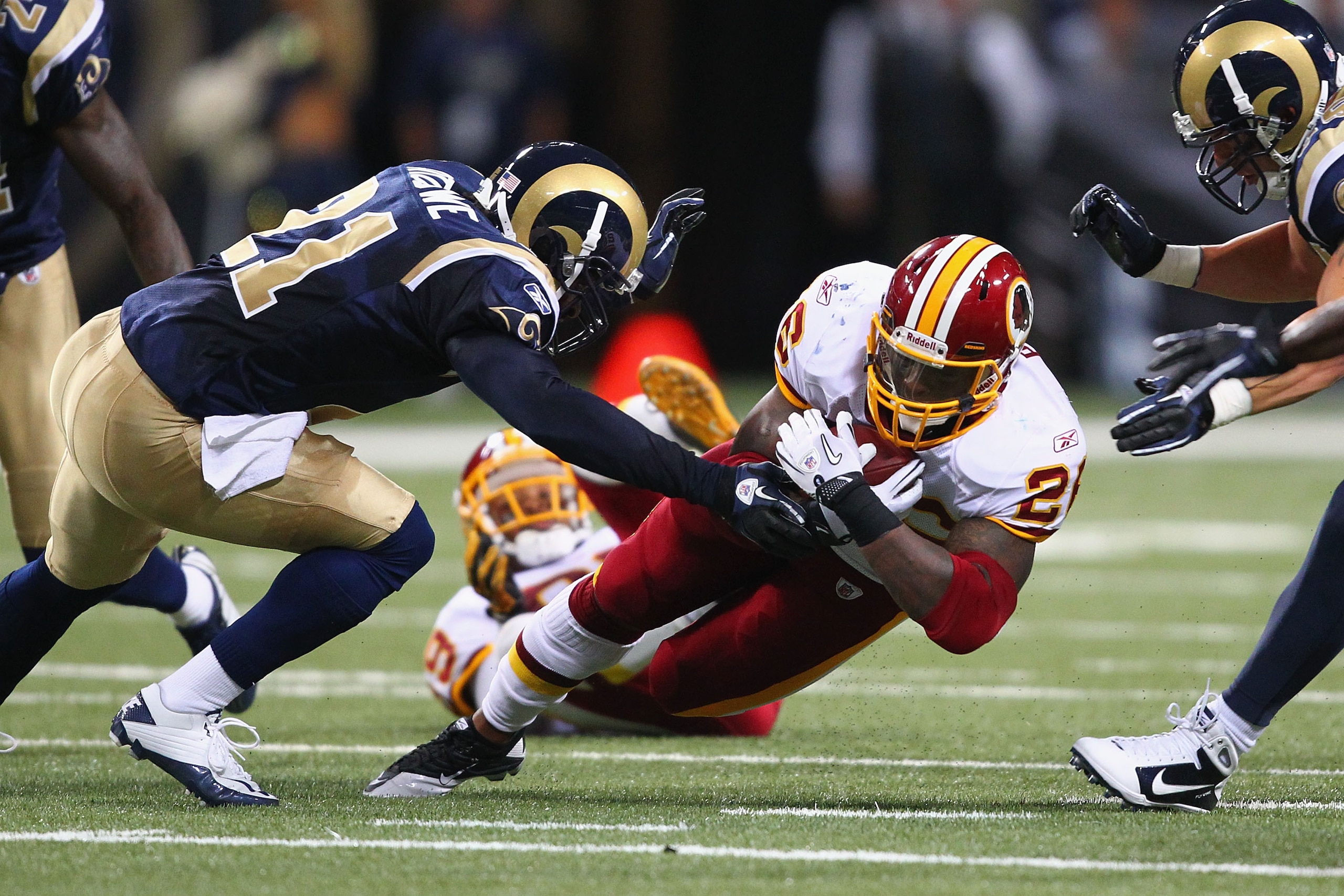 ST. LOUIS - SEPTEMBER 26: Clinton Portis #26 of the Washington Redskins is tackled against the St. Louis Rams at the Edward Jones Dome on September 26, 2010 in St. Louis, Missouri.  The Rams beat the Redskins 30-16.  (Photo by Dilip Vishwanat/Getty Images
