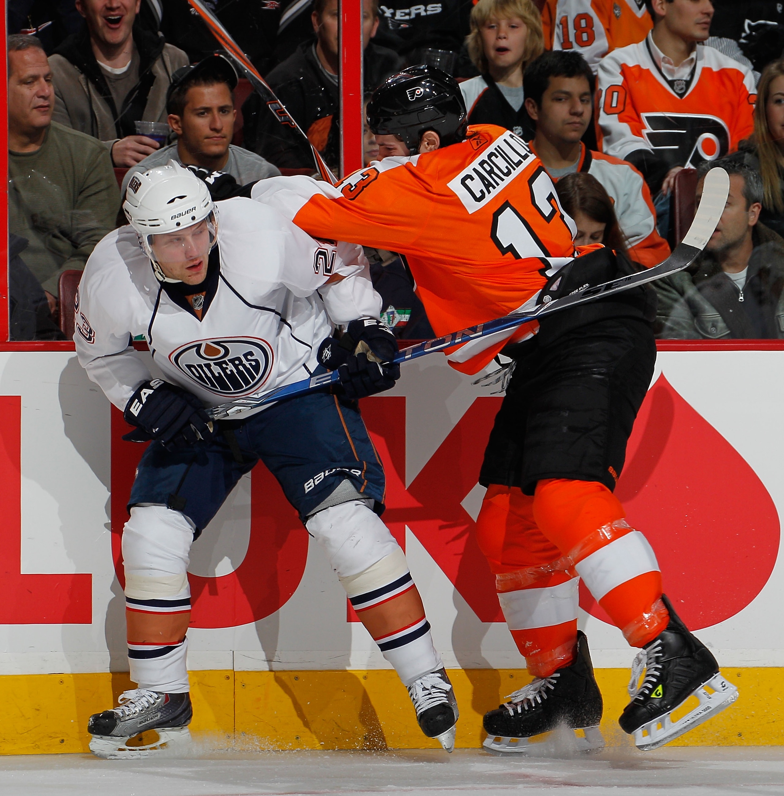 PHILADELPHIA, PA - MARCH 08:  Daniel Carcillo #13 of the Philadelphia Flyers checks Linus Omark #23 of the Edmonton Oilers during the third period of an NHL hockey game at the Wells Fargo Center on March 8, 2011 in Philadelphia, Pennsylvania. Flyers won 4