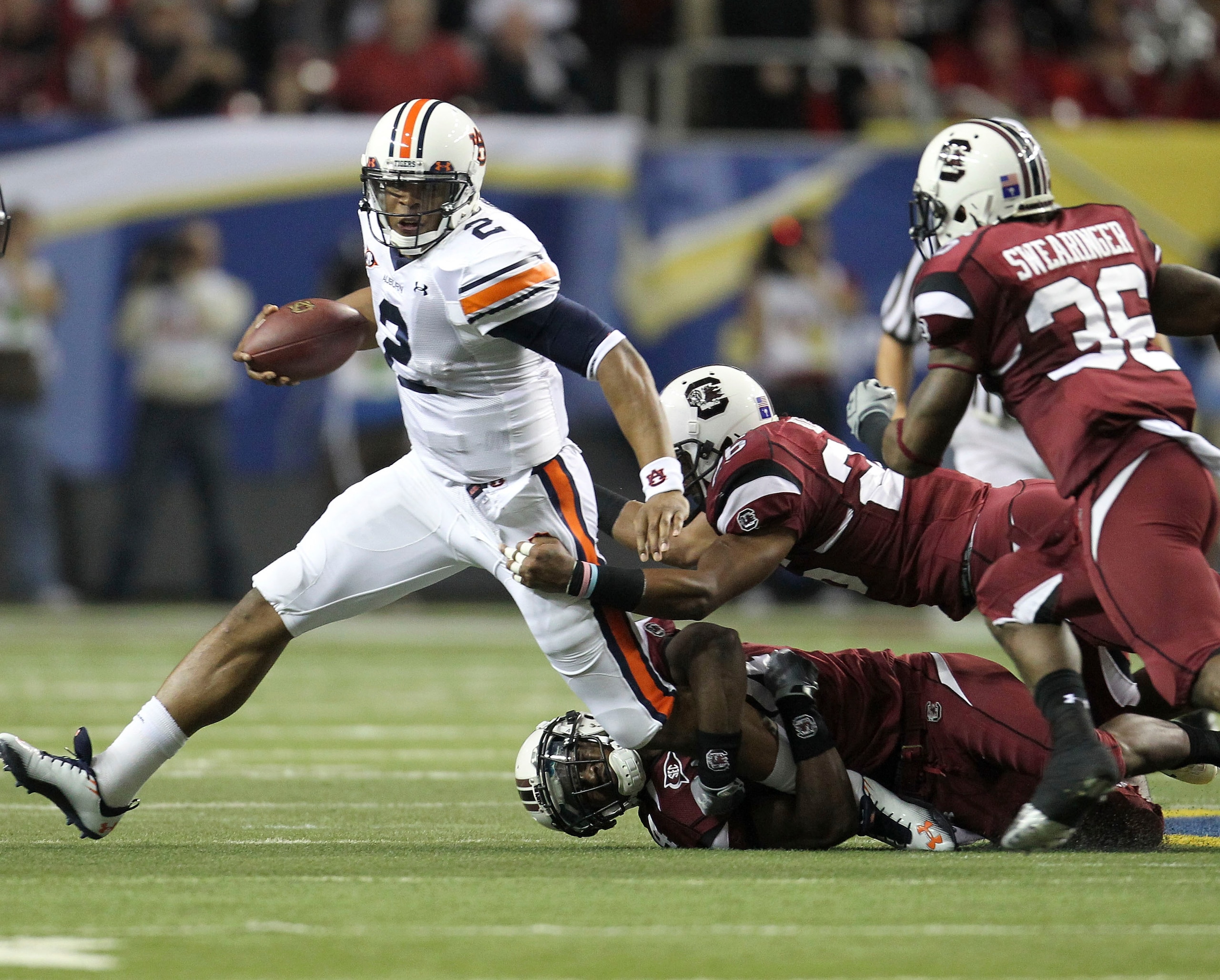 ATLANTA - DECEMBER 4:  Quarterback Cam Newton #2 of the Auburn Tigers is pursued by members of the South Carolina Gamecocks defense during the 2010 SEC Championship against the Auburn Tigers South Carolina Gamecocks at Georgia Dome on December 4, 2010 in
