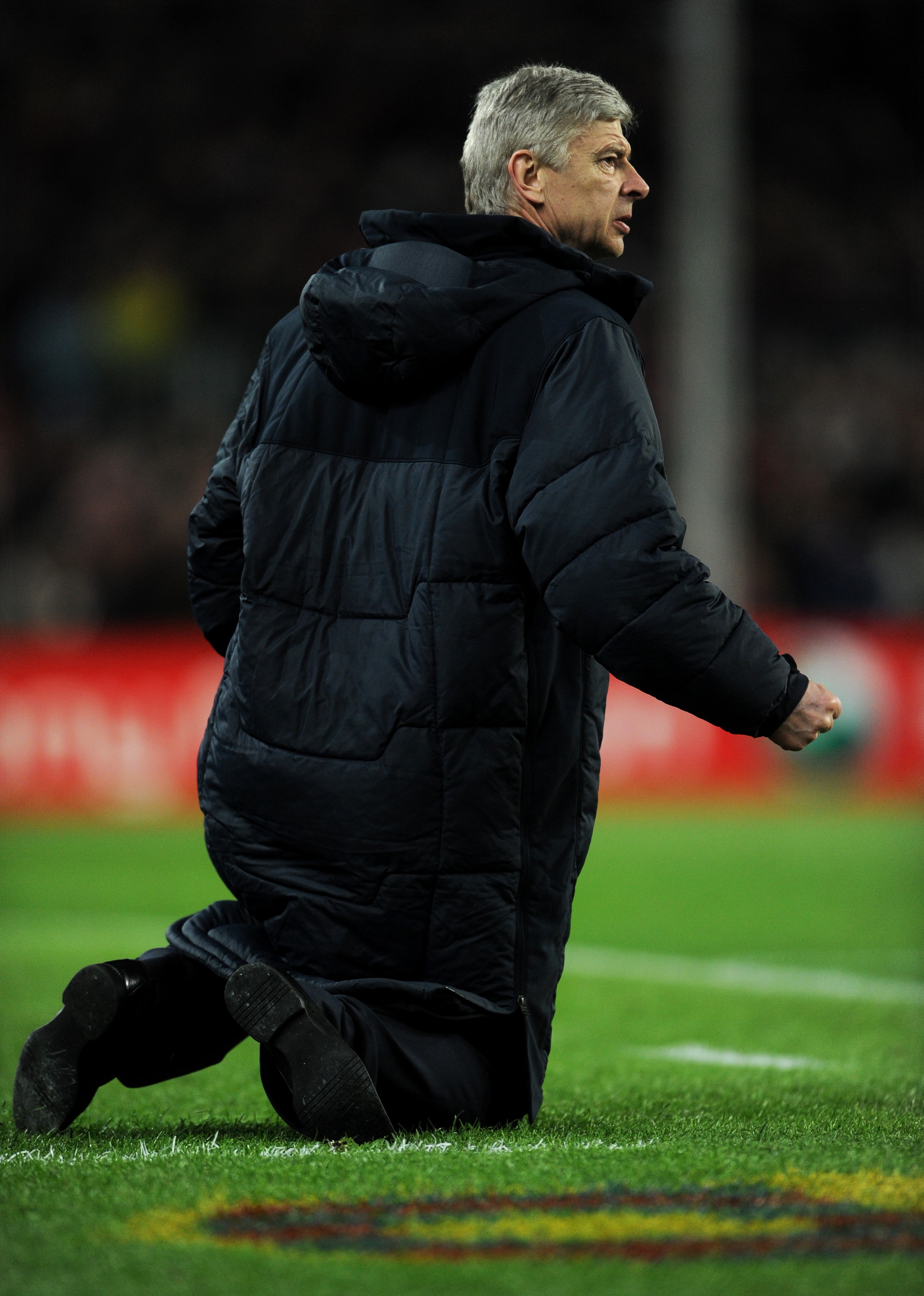 BARCELONA, SPAIN - MARCH 08:  Head coach Arsene Wenger of Arsenal sits on his knees on the pitch as he reacts to his players during the UEFA Champions League round of 16 second leg match between Barcelona and Arsenal on March 8, 2011 in Barcelona, Spain.