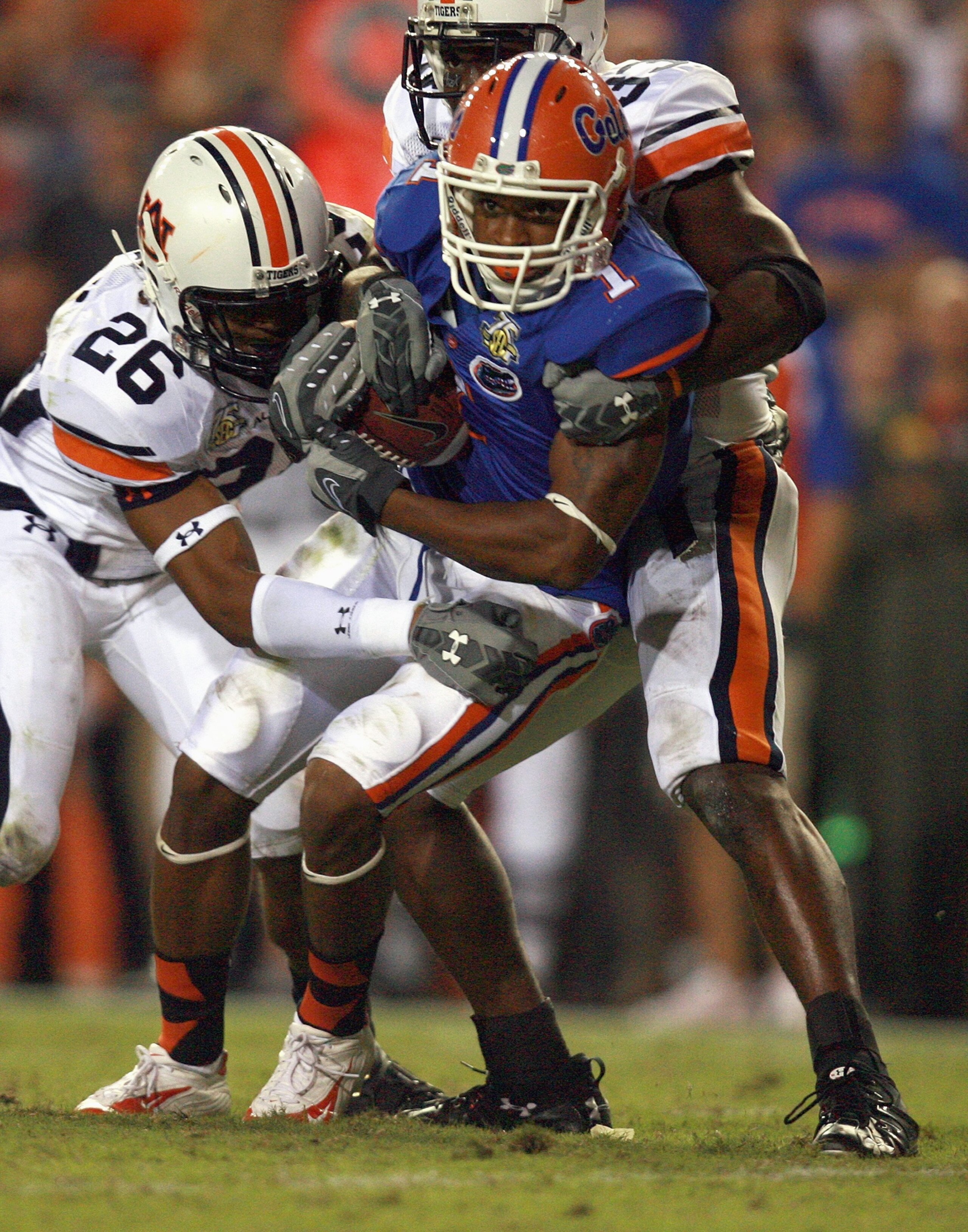GAINESVILLE, FL - SEPTEMBER 29: Percy Harvin #1 of the Florida Gators grips the ball as he is tackled by   Steve Gandy #26 of the Auburn Tigers at Ben Hill Griffin Stadium September 29, 2007 in Gainesville, Florida. Auburn defeated Florida 20-17. (Photo b