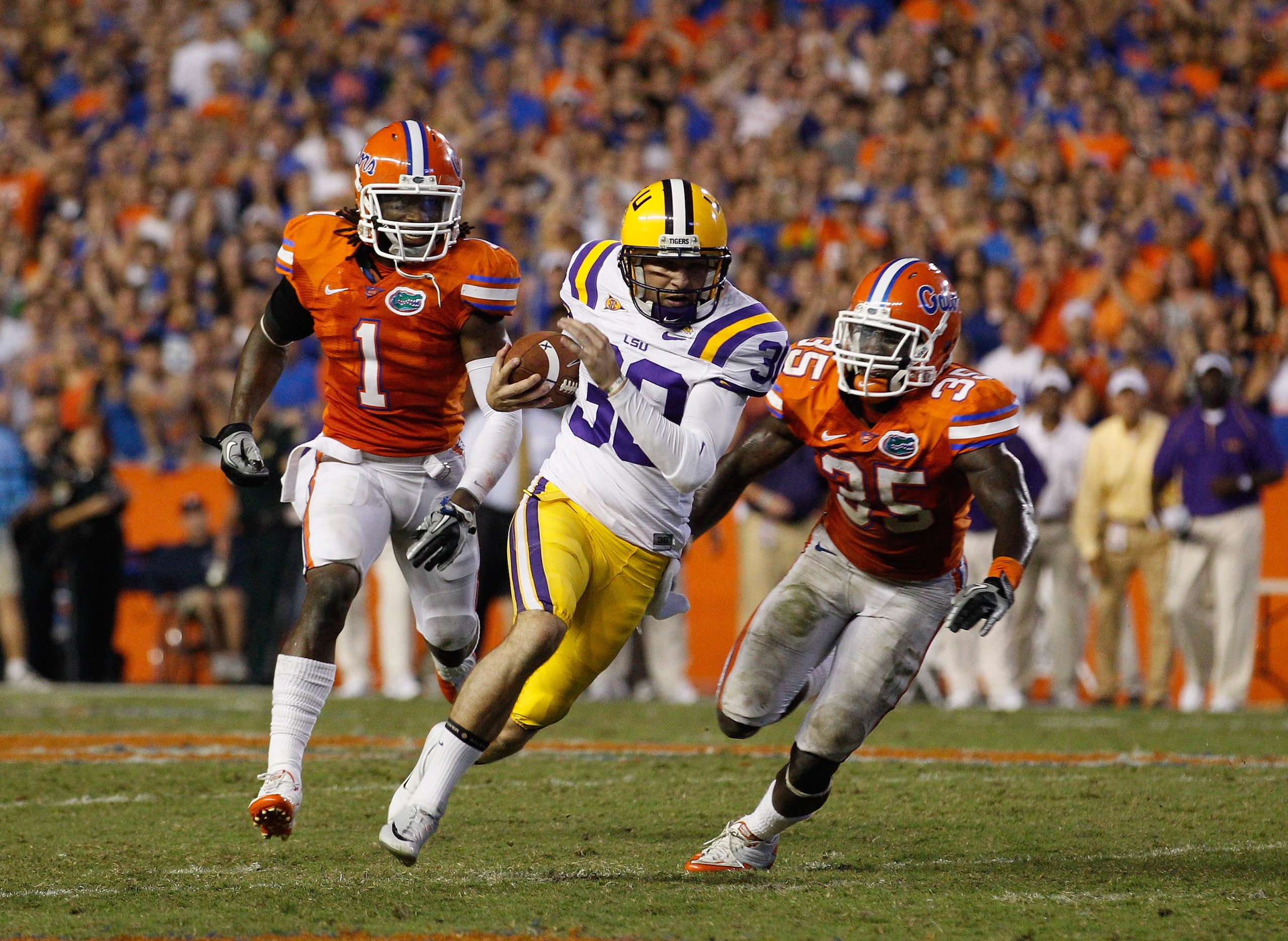 GAINESVILLE, FL - OCTOBER 09:  Punter Josh Jasper #30 of the Louisiana State University Tigers runs a fake punt for yardage past Ahmad Black #35 and Janoris Jenkins #1 of the Florida Gators during the game at Ben Hill Griffin Stadium on October 9, 2010 in