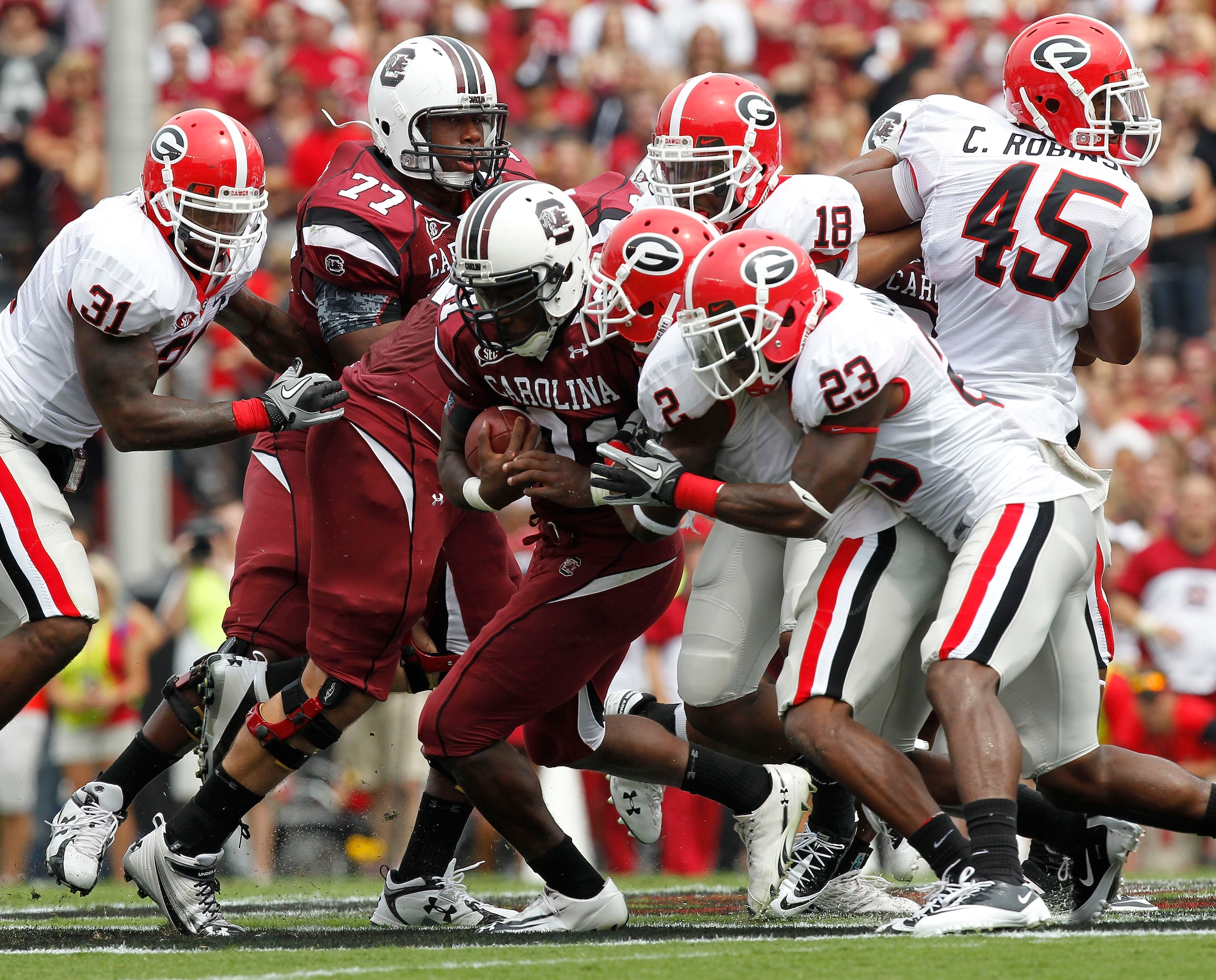 COLUMBIA, SC - SEPTEMBER 11: Tailback Marcus Lattimore #21 of the South Carolina Gamecocks (center with ball) is tackled by cornerback Brandon Boykin #2 and free safety Jakar Hamilton #23 of the Georgia Bulldogs during the game at Williams-Brice Stadium o
