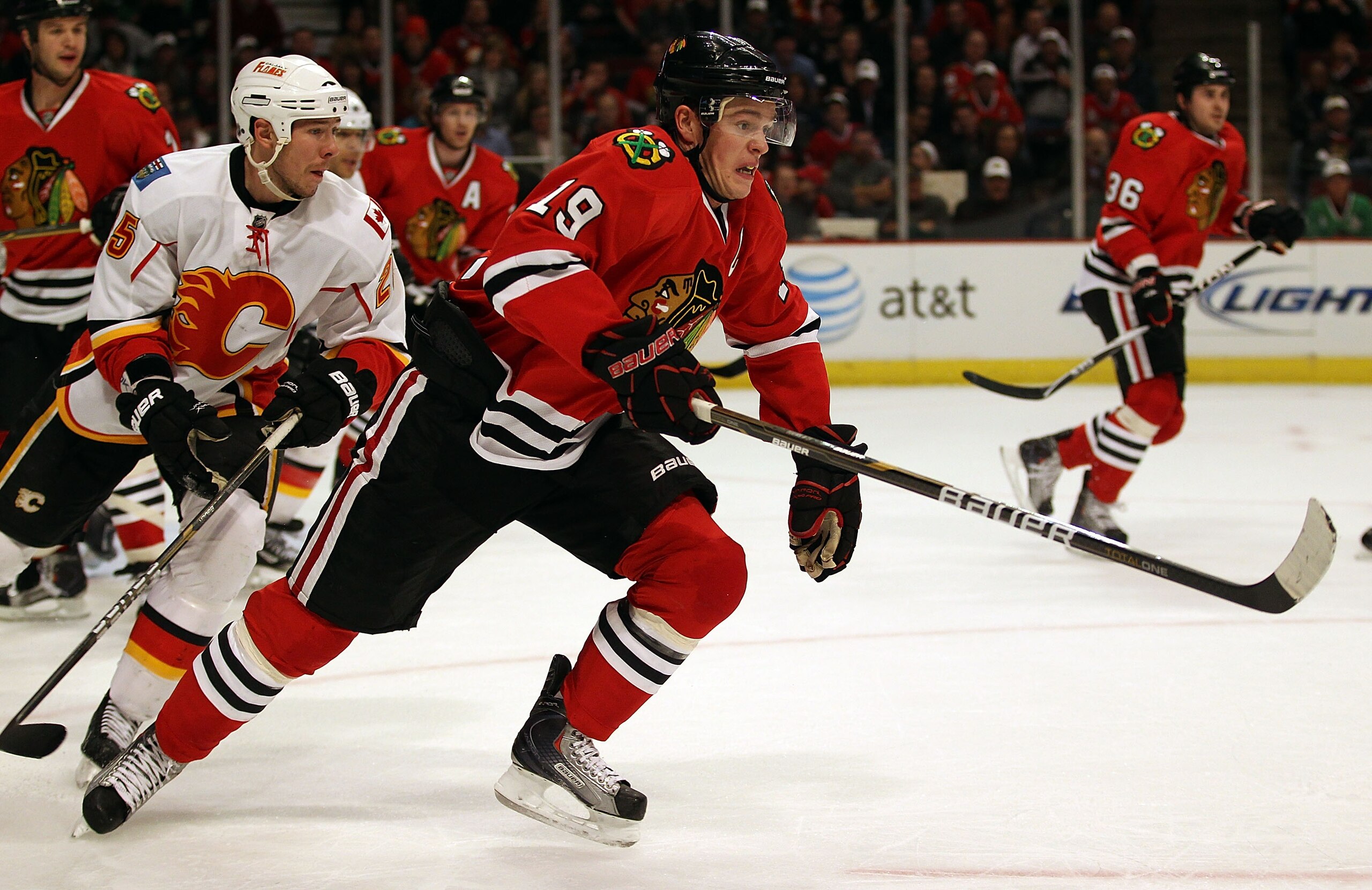 CHICAGO, IL - MARCH 02: Jonathan Toews #19 of the Chicago Blackhawks skates to the puck in front of David Moss #25 of the Calgary Flames at the United Center on March 2, 2011 in Chicago, Illinois. The Blackhawks defeated the Flames 6-4. (Photo by Jonathan CHICAGO, IL - MARCH 02: Jonathan Toews #19 of the Chicago Blackhawks skates to the puck in front of David Moss #25 of the Calgary Flames at the United Center on March 2, 2011 in Chicago, Illinois. The Blackhawks defeated the Flames 6-4. (Photo by Jonathan