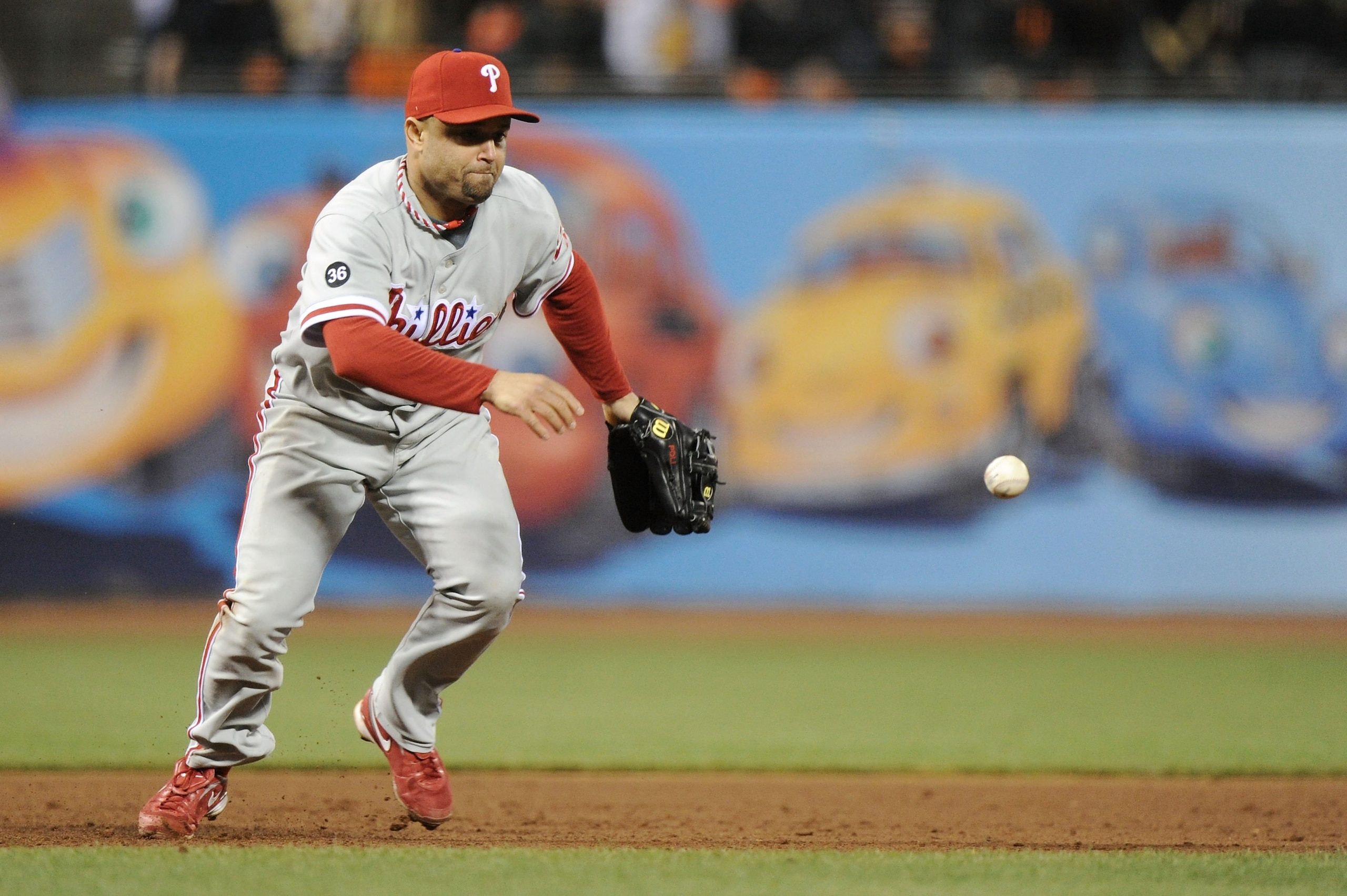 SAN FRANCISCO - OCTOBER 20:  Placido Polanco #27 of the Philadelphia Phillies misplays a ground ball hit by Edgar Renteria #16 of the San Francisco Giants in the fifth inning of Game Four of the NLCS during the 2010 MLB Playoffs at AT&T Park on October 20