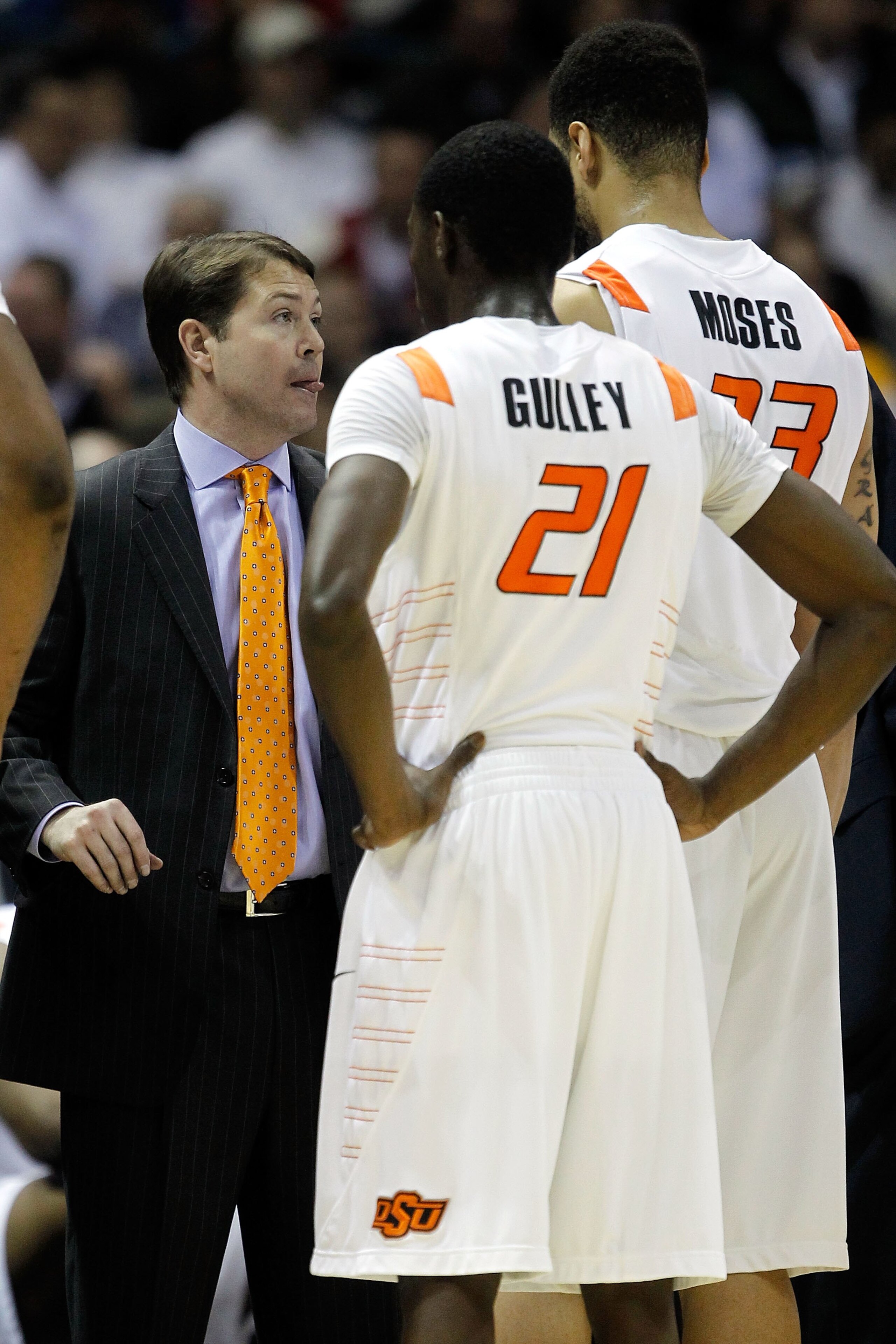 MILWAUKEE - MARCH 19:  Head coach Travis Ford of the Oklahoma State Cowboys talks with Marshall Moses #33 and Fred Gulley #21 while taking on the Georgia Tech Yellow Jackets during the first round of the 2010 NCAA men's basketball tournament at the Bradle