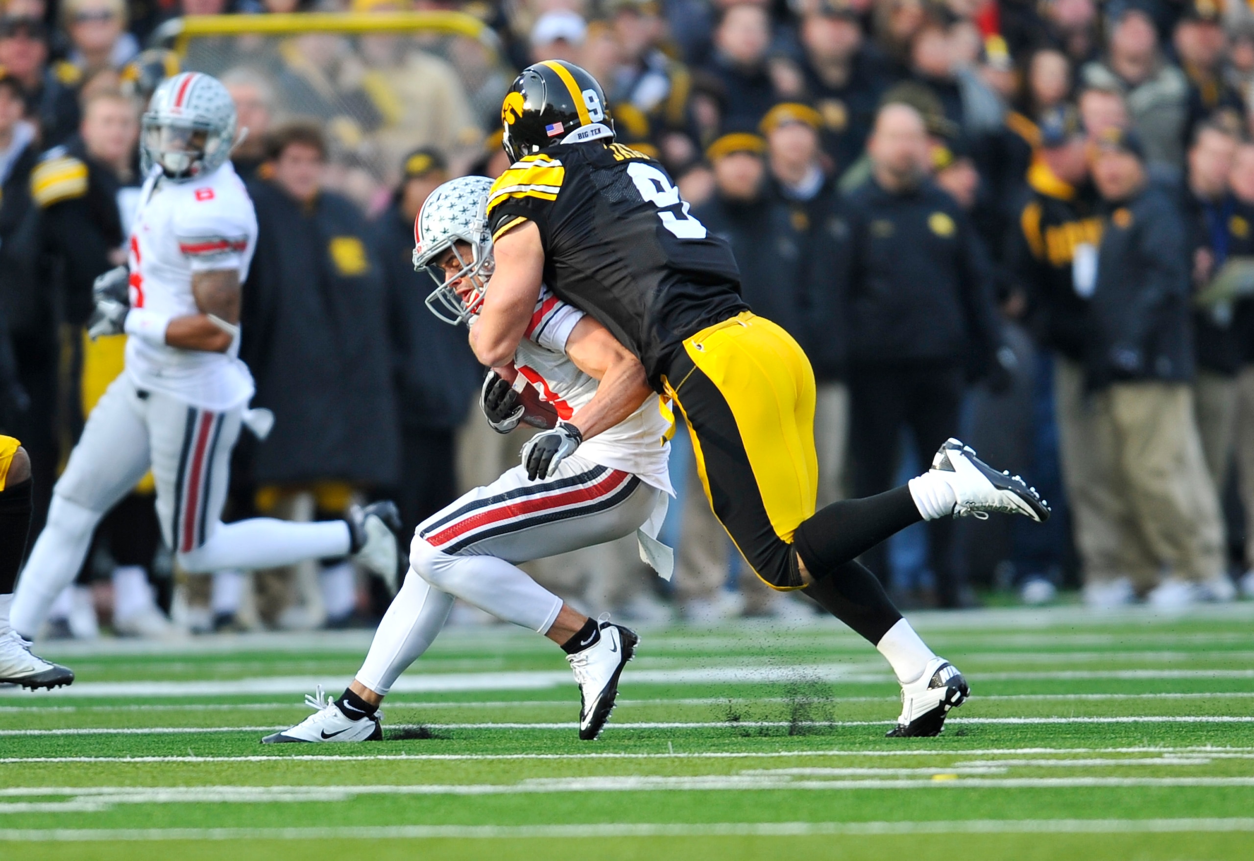 IOWA CITY, IA - NOVEMBER 20: Defensive back Tyler Sash #9 of the University of Iowa Hawkeyes tackles wide receiver Dane Sanzenbacher #12 of the Ohio State Buckeyes during the first half of play at Kinnick Stadium on November 20, 2010 in Iowa City, Iowa. O