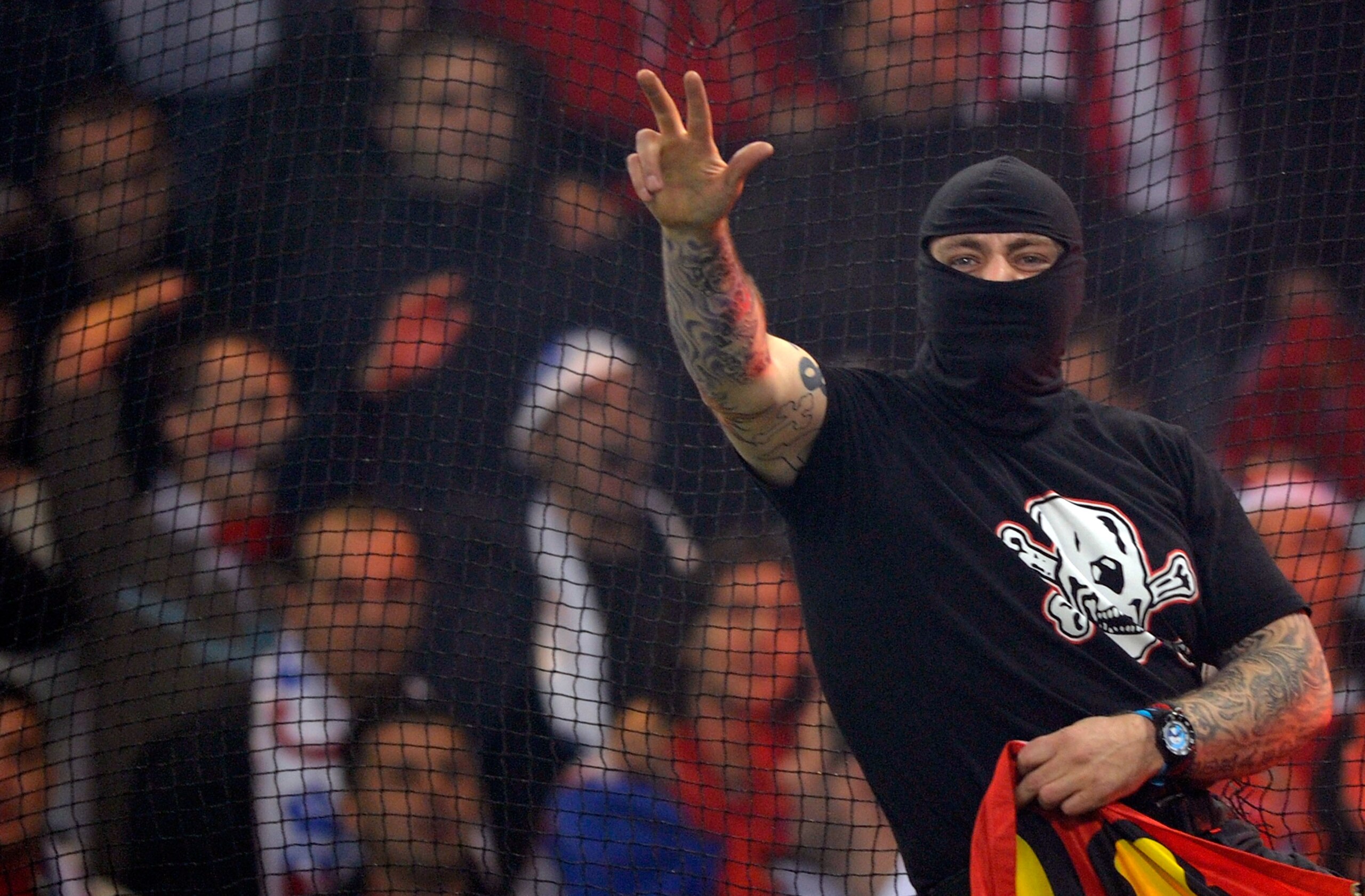 GENOA, ITALY - OCTOBER 12:  Balaclava clad Serbian fan Ivan Bogdanov gestures towards riot police during the UEFA Euro 2012 qualifying match between Italy and Serbia at Luigi Ferraris Stadium on October 12, 2010 in Genoa, Italy.  (Photo by Claudio Villa/G