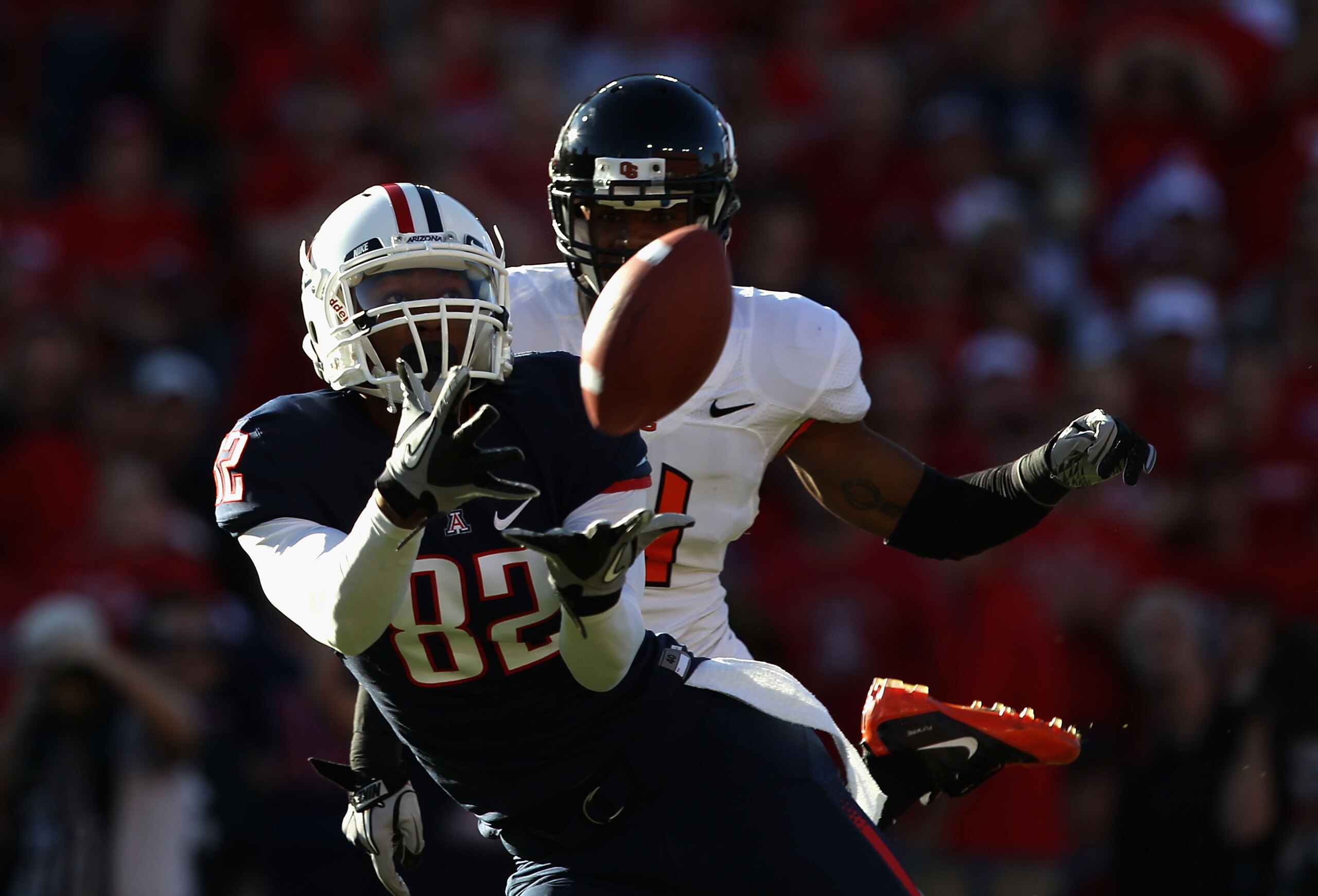 TUCSON, AZ - OCTOBER 09:  Wide receiver Juron Criner #82 of the Arizona Wildcats catches a 45 yard touchdown reception past James Dockery #4 of the Oregon State Beavers during the first quarter of the college football game at Arizona Stadium on October 9,