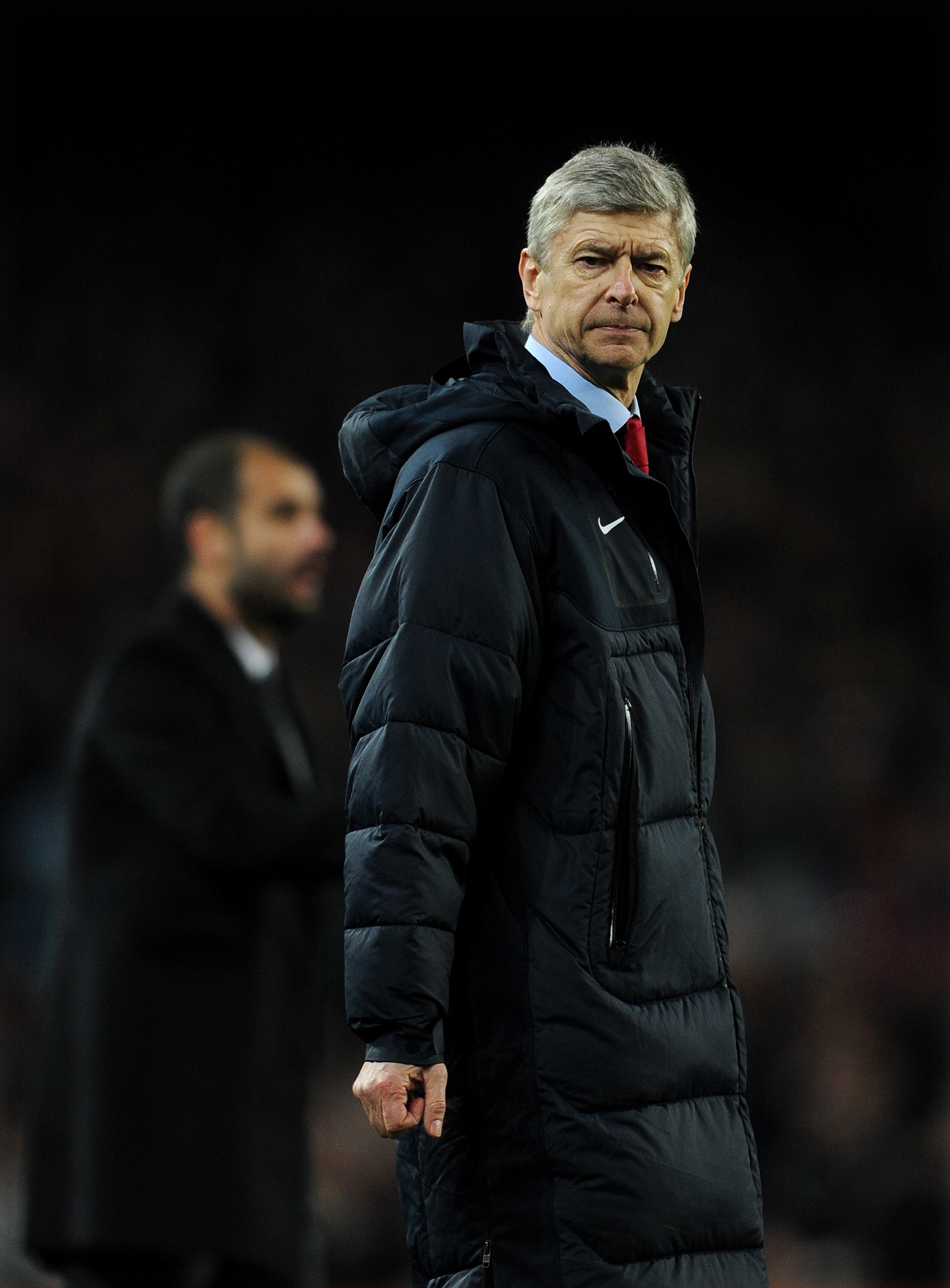 BARCELONA, SPAIN - MARCH 08:  Head coach Arsene Wenger of Arsenal reacts backdropped by head coach Josep Guardiola of Barcelona during the UEFA Champions League round of 16 second leg match between Barcelona and Arsenal on March 8, 2011 in Barcelona, Spai