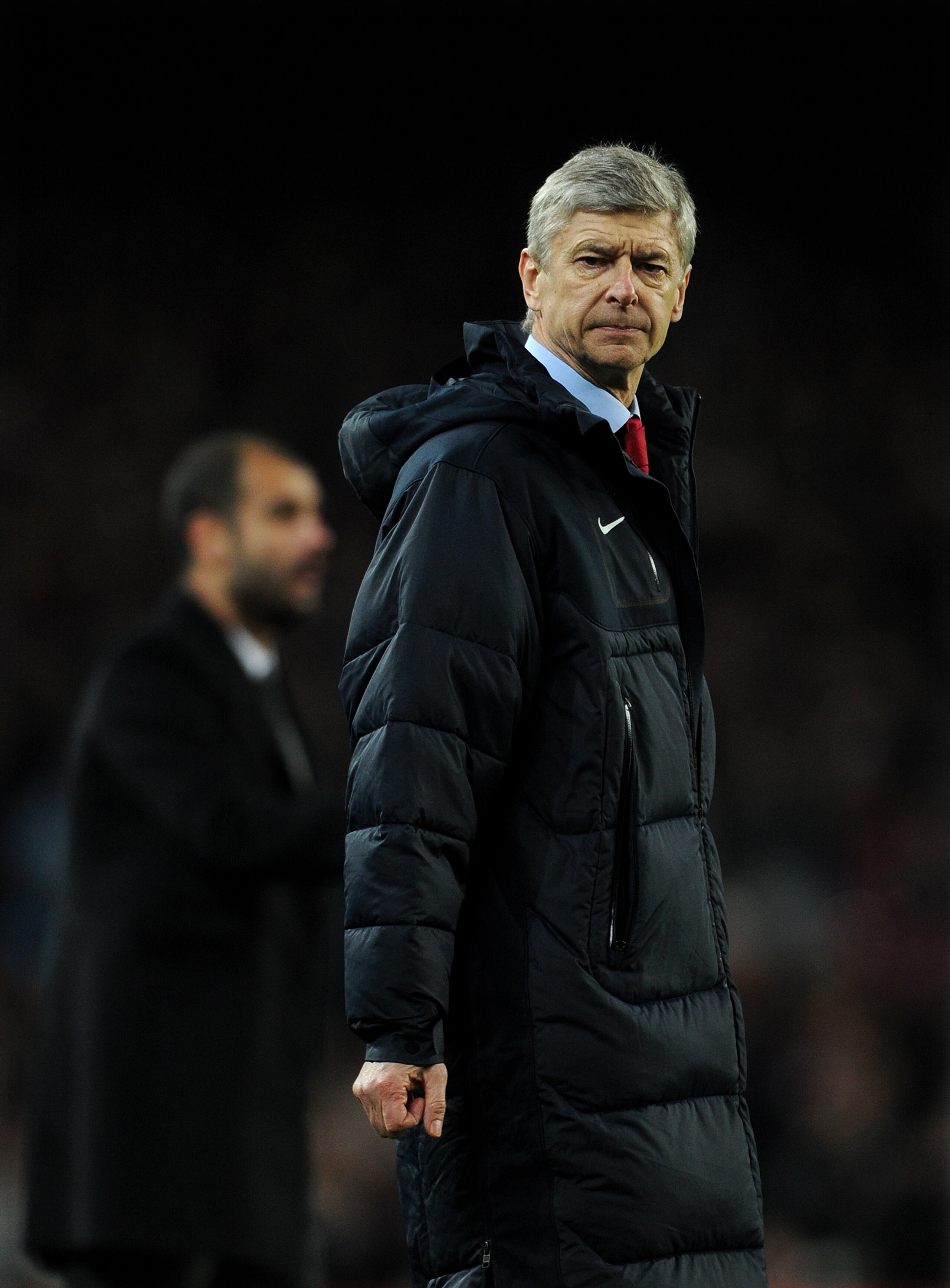 BARCELONA, SPAIN - MARCH 08:  Head coach Arsene Wenger of Arsenal reacts backdropped by head coach Josep Guardiola of Barcelona during the UEFA Champions League round of 16 second leg match between Barcelona and Arsenal on March 8, 2011 in Barcelona, Spai