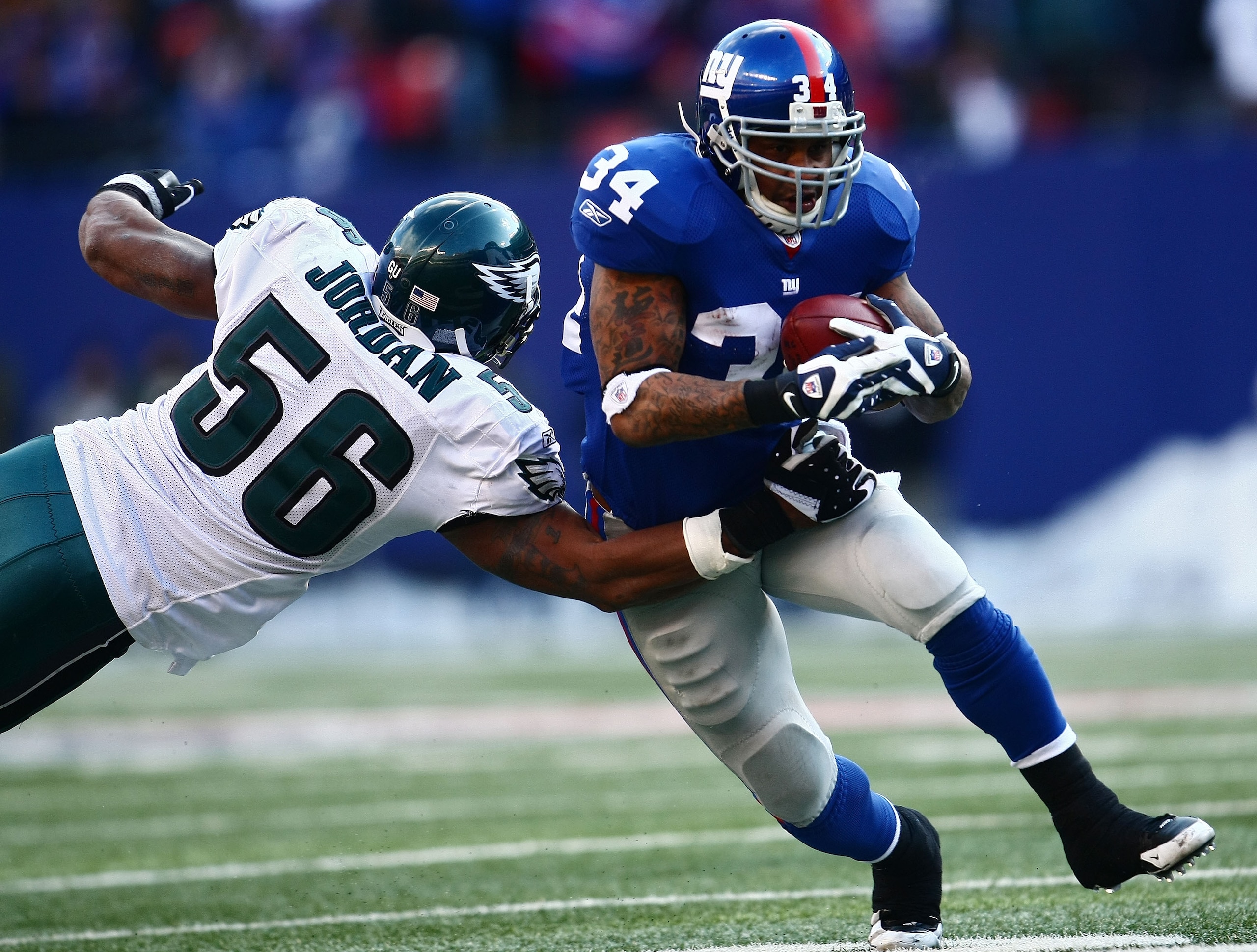 EAST RUTHERFORD, NJ - JANUARY 11:  Derrick Ward #34 of the New York Giants runs against Akeem Jordan #56 of the Philadelphia Eagles during the NFC Divisional Playoff Game on January 11, 2009 at Giants Stadium in East Rutherford, New Jersey.  (Photo by Chr