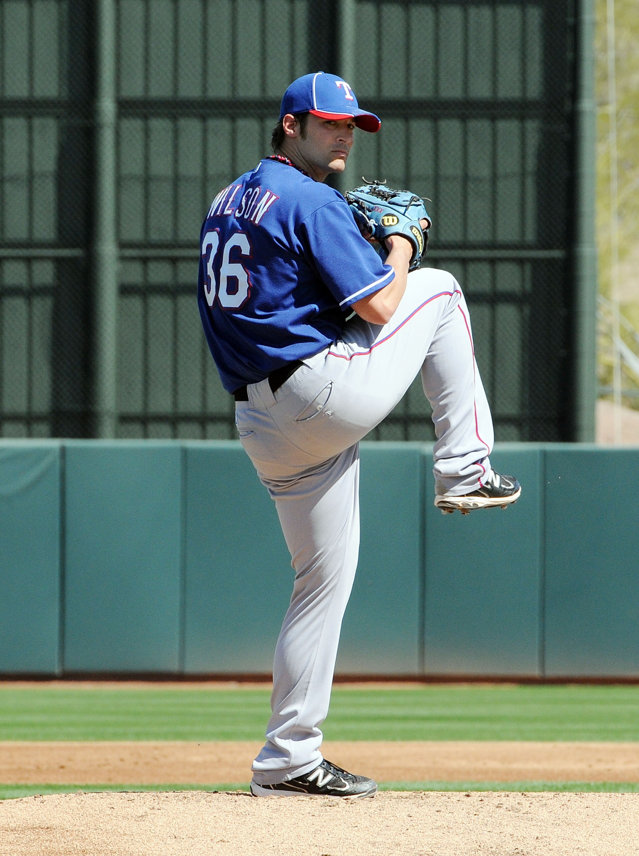PHOENIX, AZ - MARCH 04:  C.J. Wilson #36 of the Texas Rangers delivers a pitch against the Oakland Athletics at Phoenix Municipal Stadium on March 4, 2011 in Phoenix, Arizona.  (Photo by Norm Hall/Getty Images)
