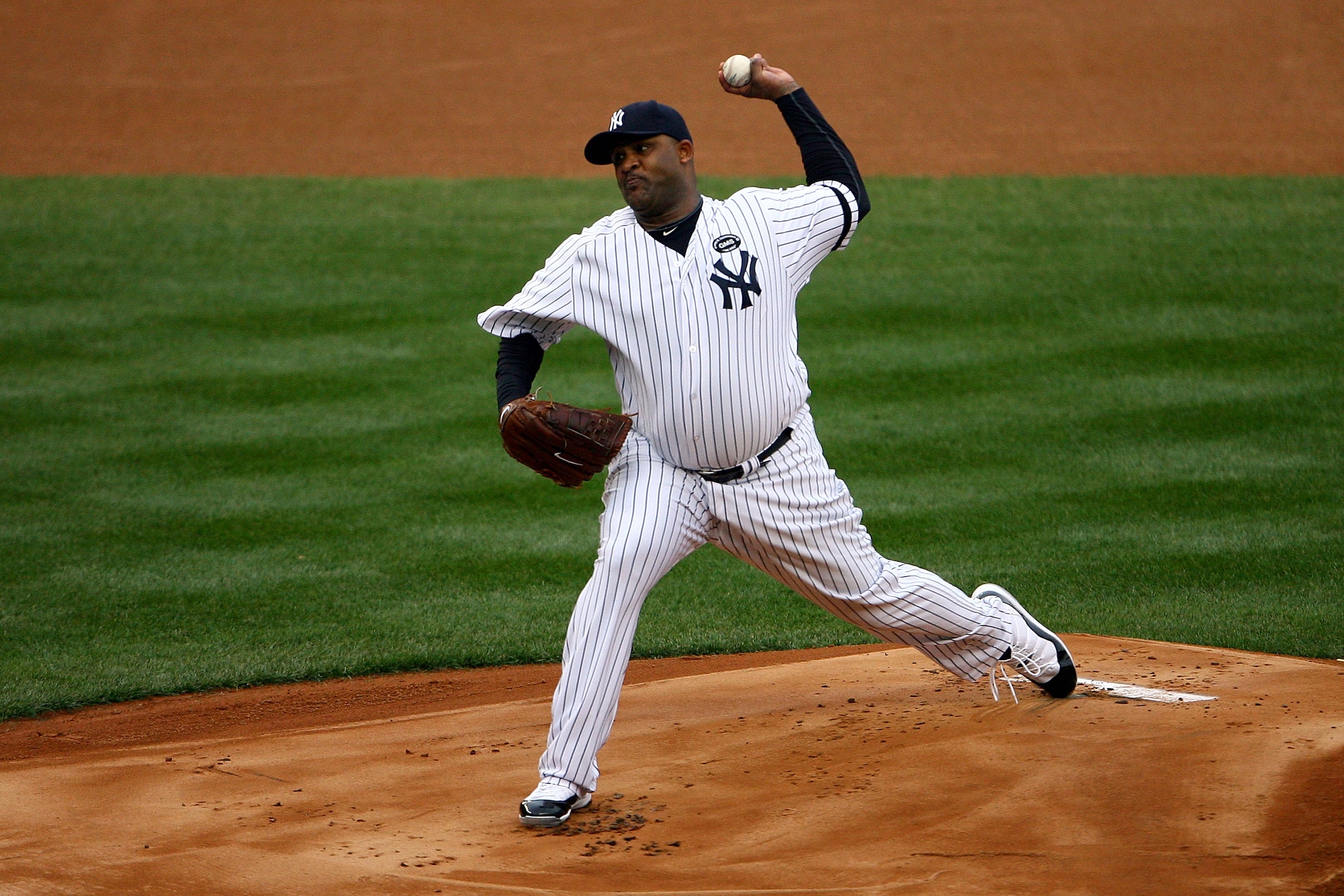 NEW YORK - OCTOBER 20:  CC Sabathia #52 of the New York Yankees pitches against the Texas Rangers in Game Five of the ALCS during the 2010 MLB Playoffs at Yankee Stadium on October 20, 2010 in the Bronx borough of New York City.  (Photo by Andrew Burton/G