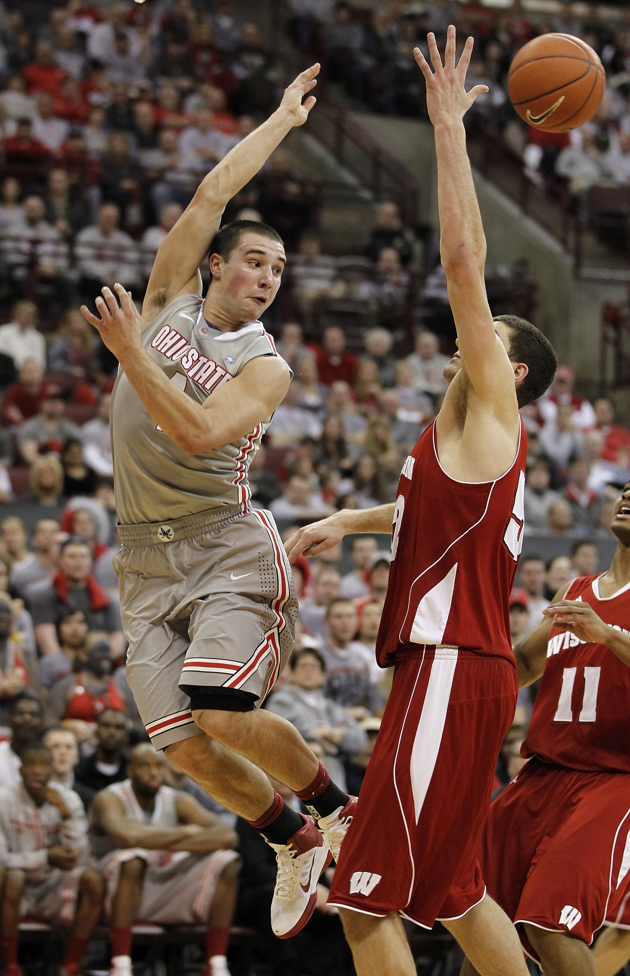COLUMBUS, OH - MARCH 06:  Aaron Craft #4 of the Ohio State Buckeyes passes around Keaton Nankivil #52 of the Wisconsin Badgers on March 6, 2011 at the Value City Arena in Columbus, Ohio.  (Photo by Gregory Shamus/Getty Images)