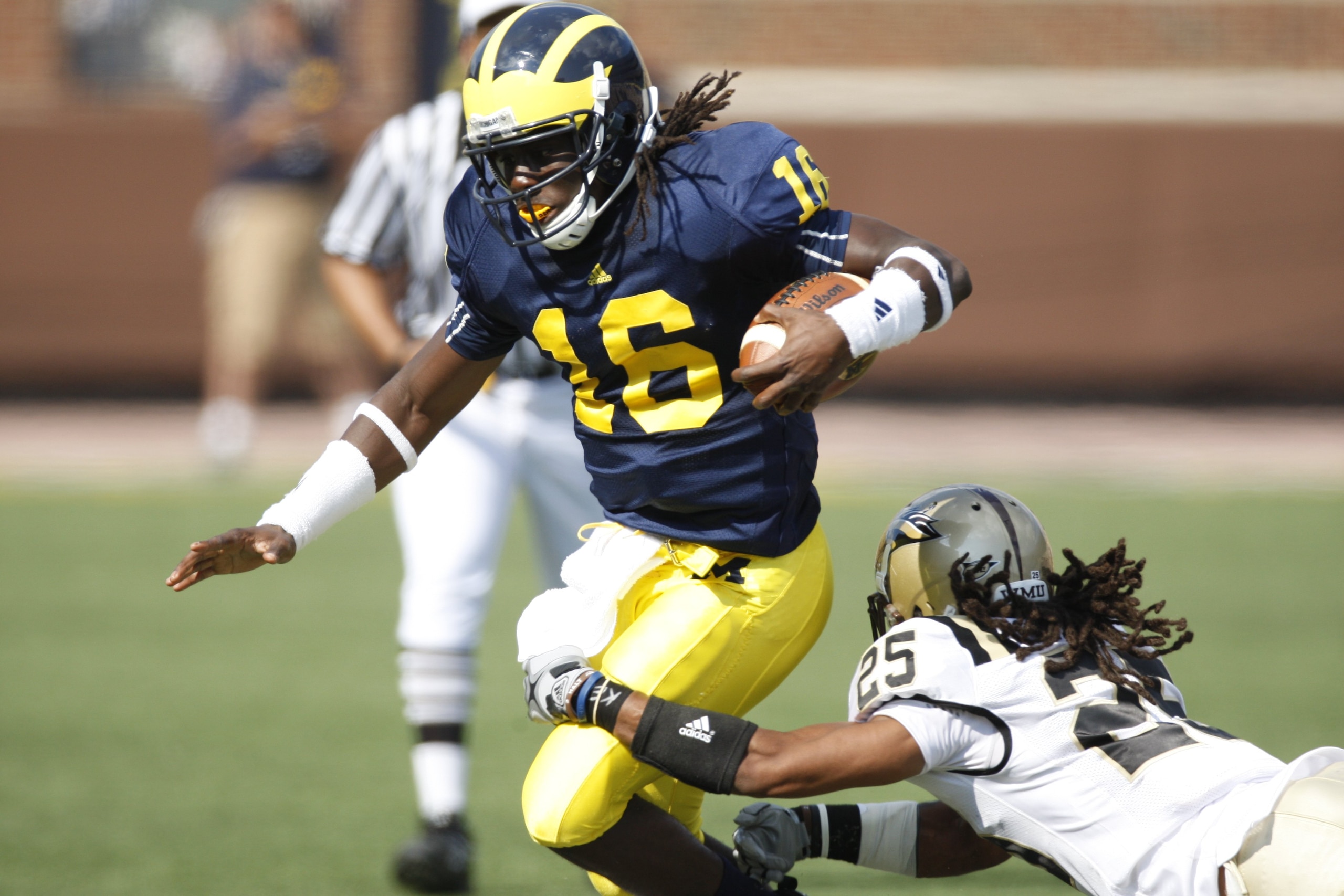 ANN ARBOR, MI - SEPTEMBER 5:  Denard Robinson #16 of the Michigan Wolverines carries the ball against David Lewis #26 of the Western Michigan Broncos during the game on September 5, 2009 at Michigan Stadium in Ann Arbor, Michigan. (Photo by Gregory Shamus