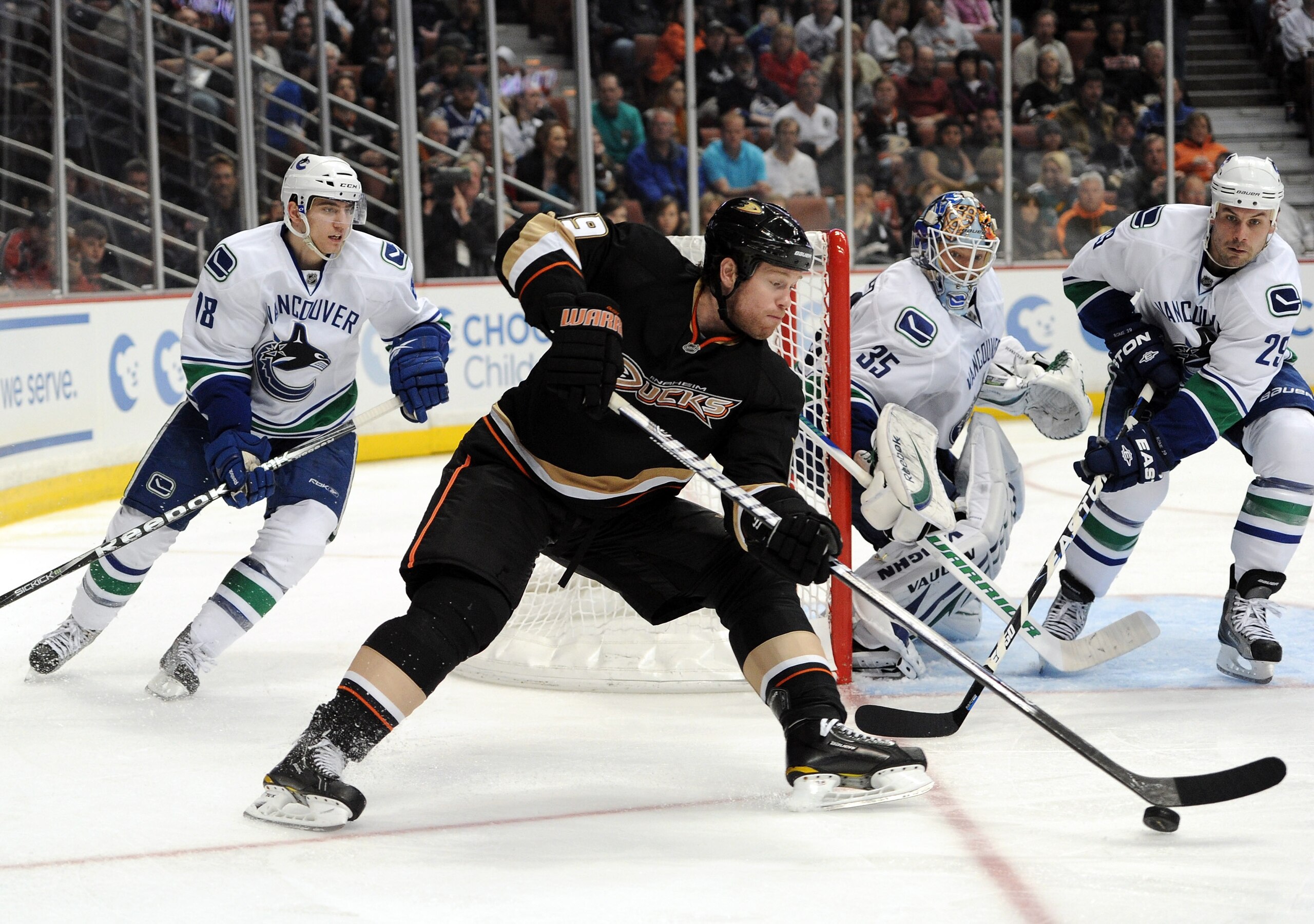 ANAHEIM, CA - MARCH 06:  Brad Winchester #19 of the Anaheim Ducks gets control of the puck in front of Cory Schneider #35, Christopher Tanev #18 and Aaron Rome #29 of the Vancouver Canucks at the Honda Center on March 6, 2011 in Anaheim, California.  (Pho