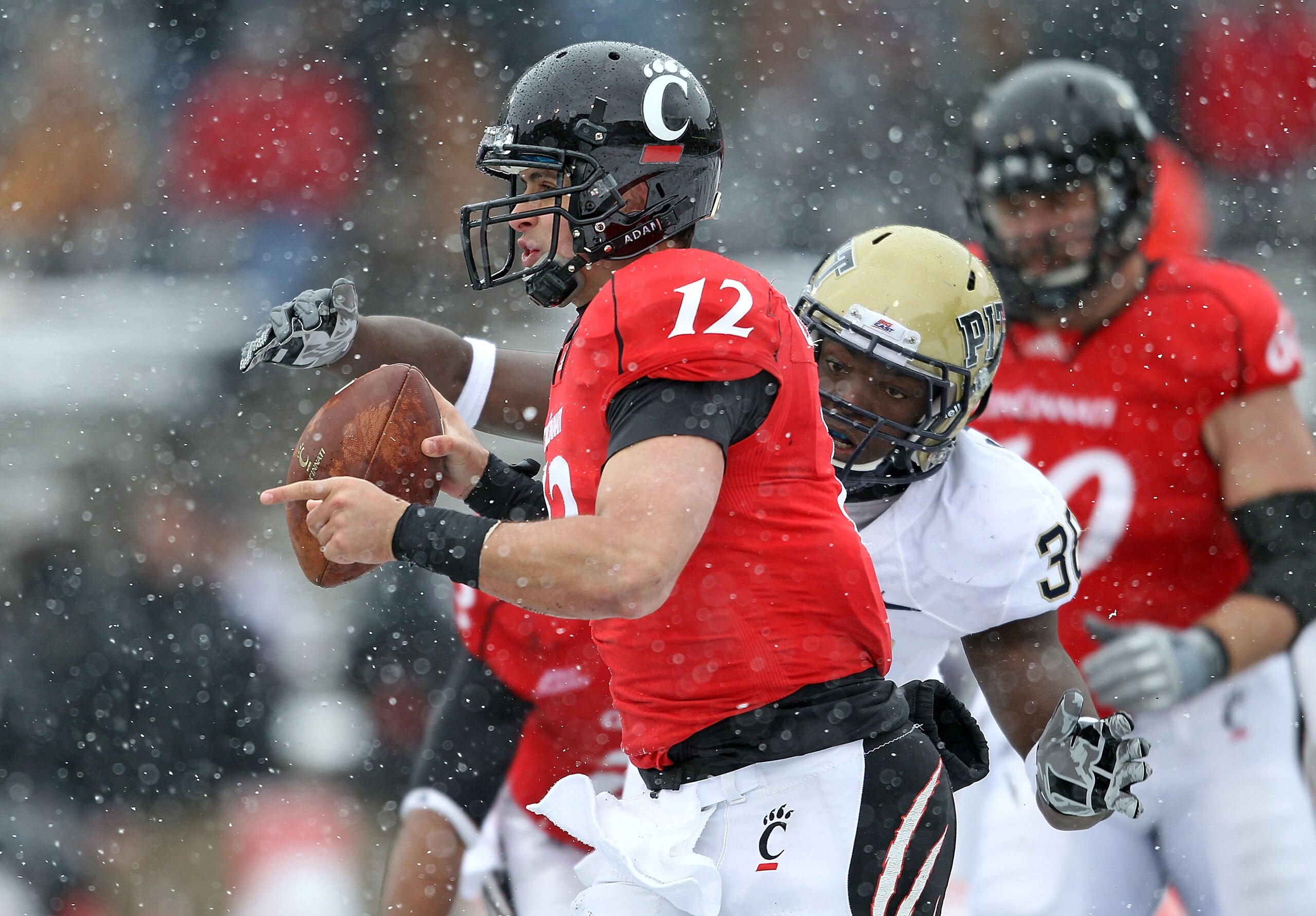 CINCINNATI, OH - DECEMBER 04:  Greg Williams #38 of the Pittsburgh Panthers reaches for Zach Collaros #12 of the Cincinnati Bearcats during the Big East Conference game against at Nippert Stadium on December 4, 2010 in Cincinnati, Ohio.  Pittsburgh won 28