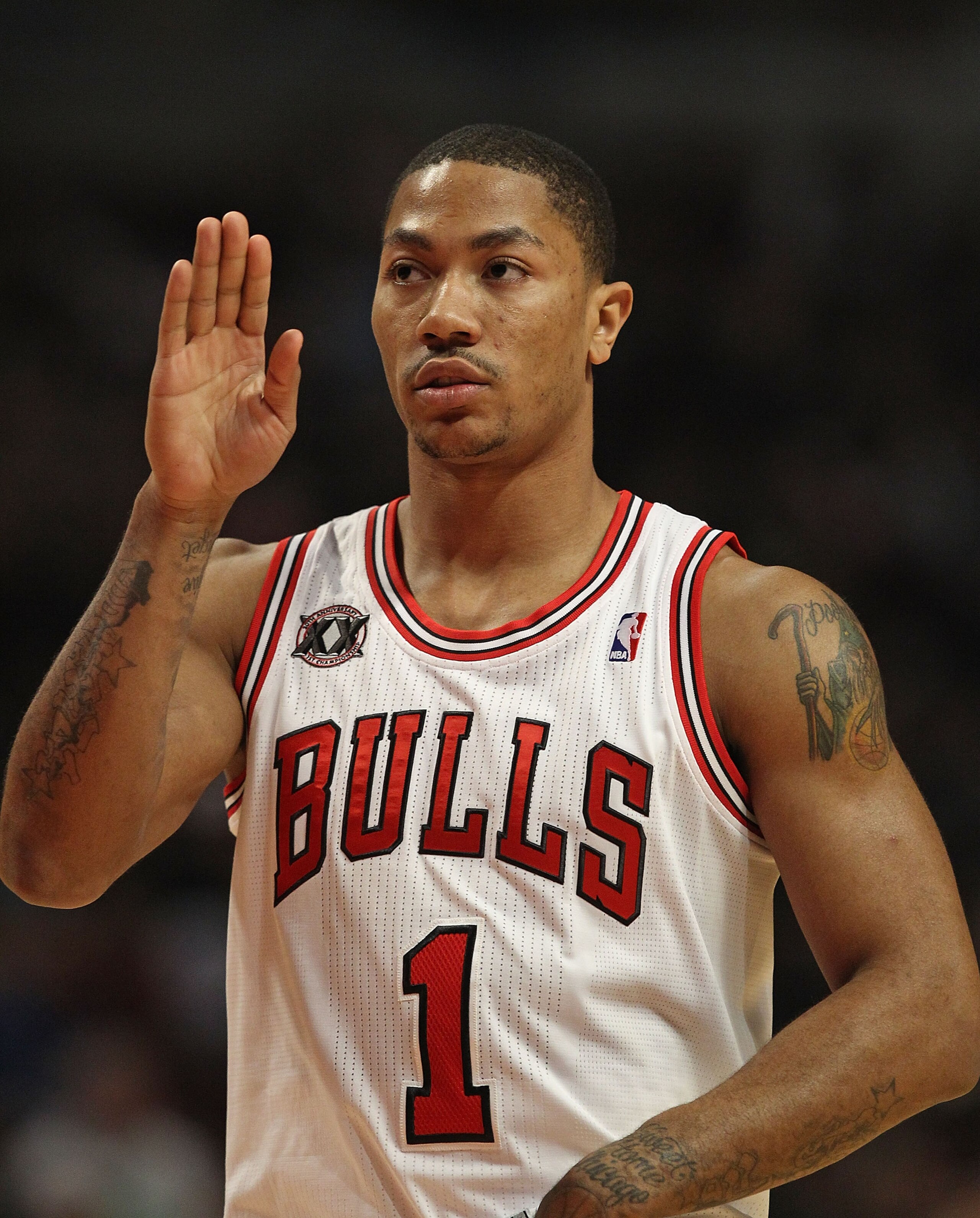 CHICAGO, IL - MARCH 07: Derrick Rose #1 of the Chicago Bulls waves to members of his family in the stands before the tip-off of a game against the New Orleans Hornets at the United Center on March 7, 2011 in Chicago, Illinois. The Bulls defeated the Horne