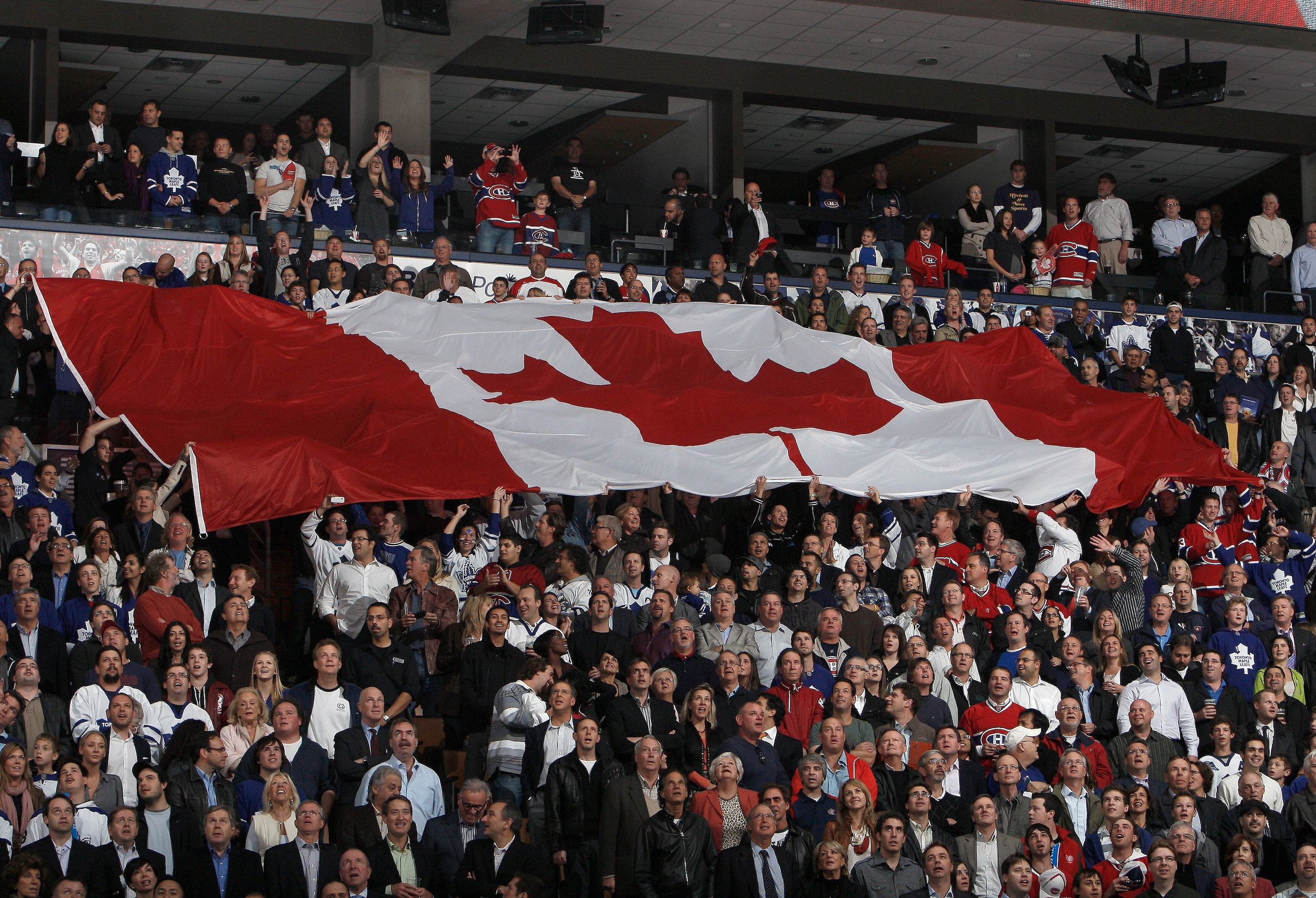 TORONTO, CANADA - OCTOBER 07: A giant Canadian flag is passed around during an opening night pre-game ceremony before a regular season NHL game between the Toronto Maple Leafs  and the Montreal Canadiens at the Air Canada Centre October 7, 2010 in Toronto