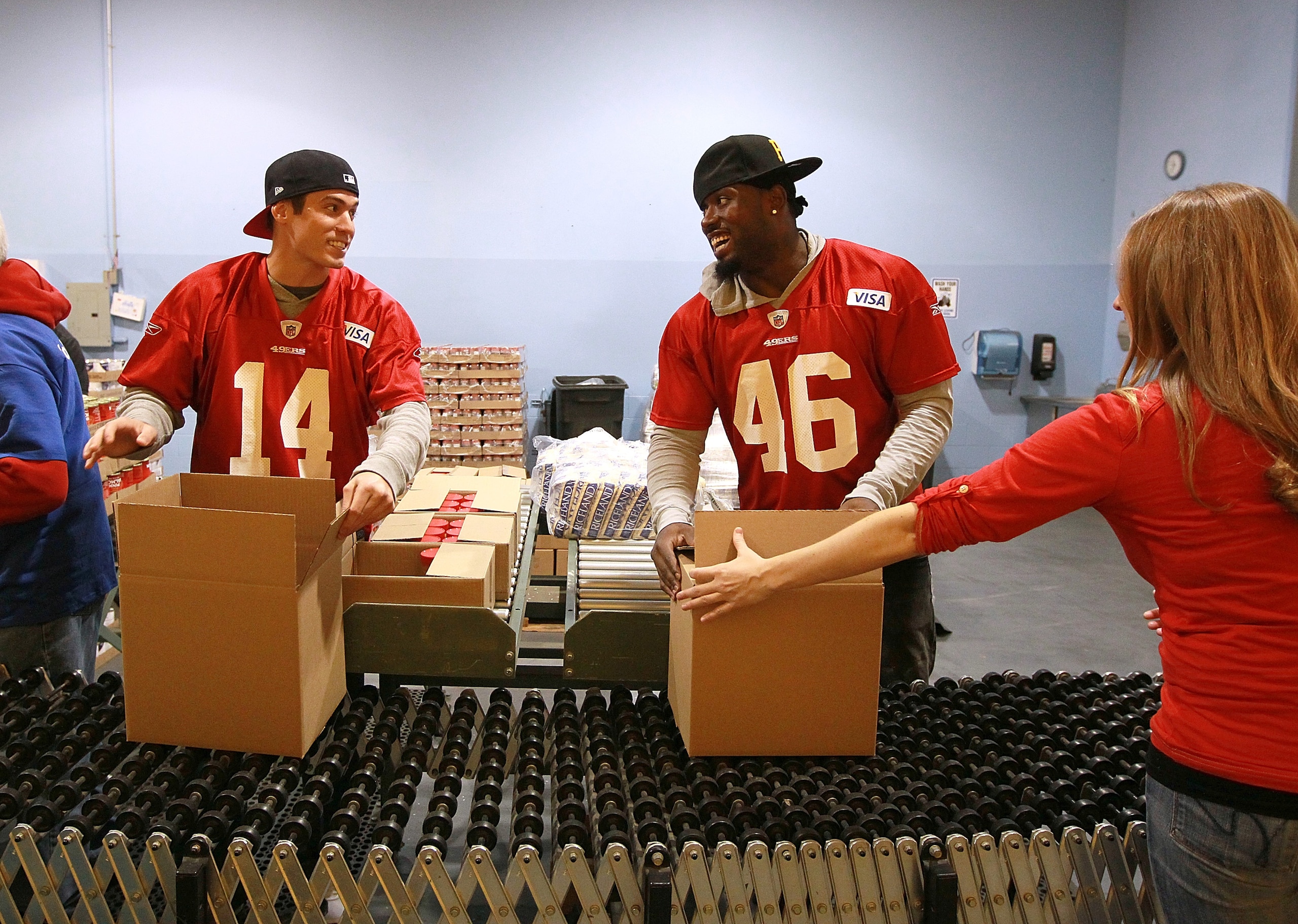 SAN FRANCISCO - NOVEMBER 09:  Kevin Jurovich (L) and Delanie Walker of the San Francisco 49ers pack boxes of food while volunteering at the San Francisco Food Bank on November 9, 2010 in San Francisco, California. With only a few weeks to go before the st