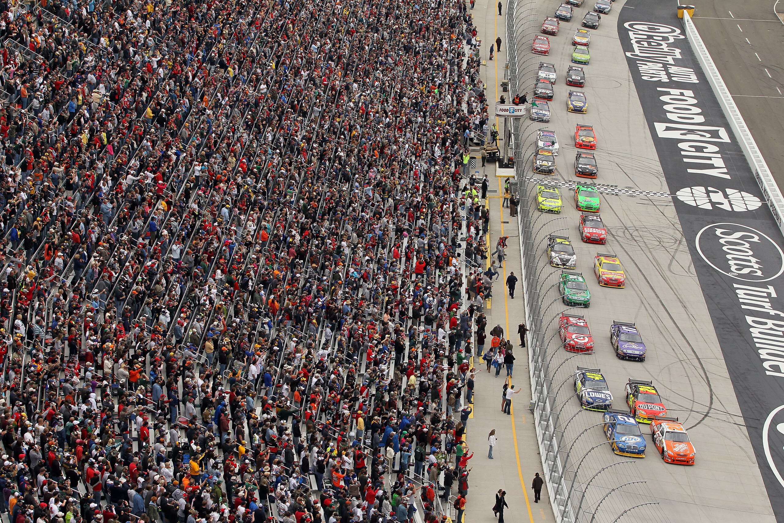 BRISTOL, TN - MARCH 21:  Joey Logano, driver of the #20 Home Depot Toyota, and Kurt Busch, driver of the #2 Miller Lite Dodge, lead the field to the green flag to start the NASCAR Sprint Cup Series Food City 500 at Bristol Motor Speedway on March 21, 2010